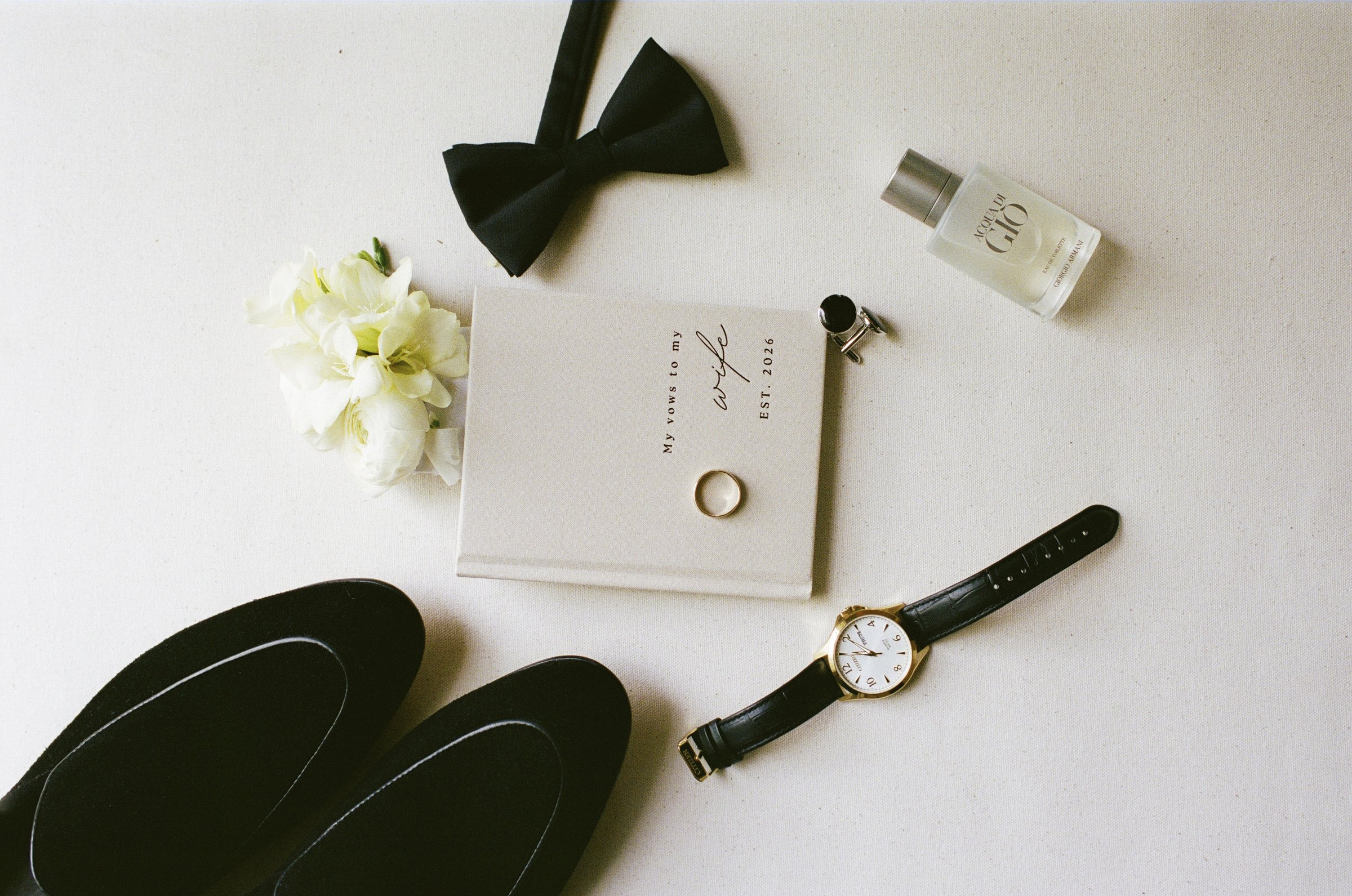 Avery's bow tie, watch and boutonniere laid out in the farmhouse