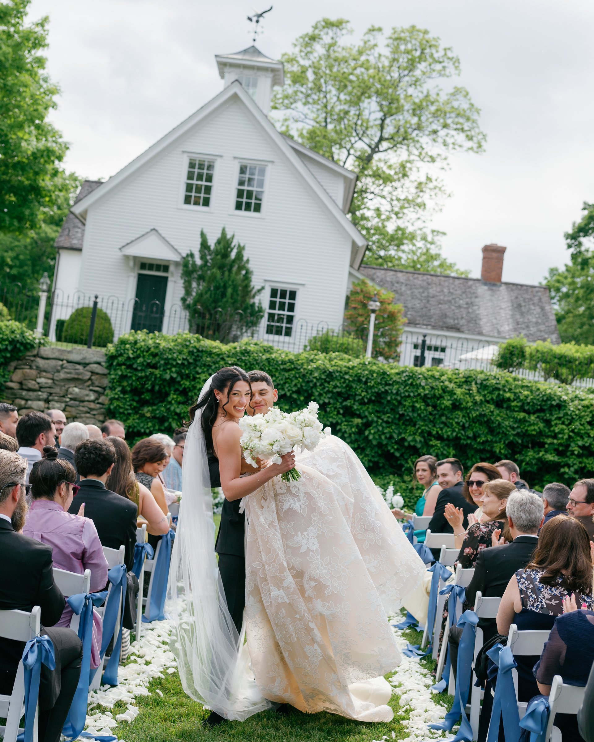 Avery lifting Kayla in the aisle after the ceremony as guests cheer on both sides