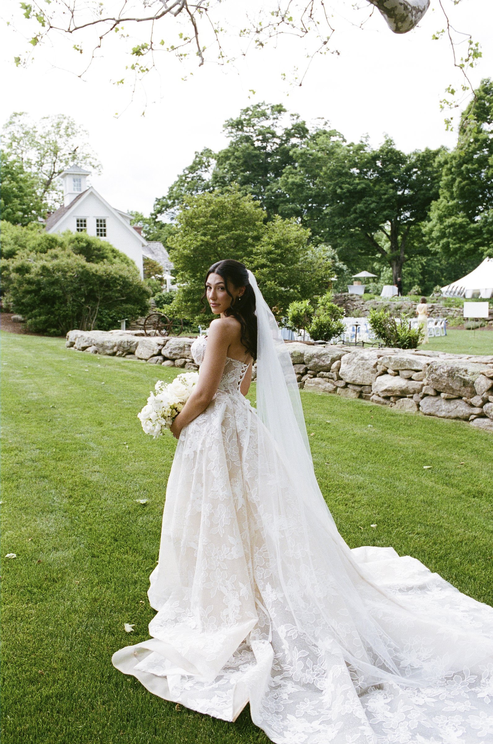 Kayla holding her white bouquet on the lawn