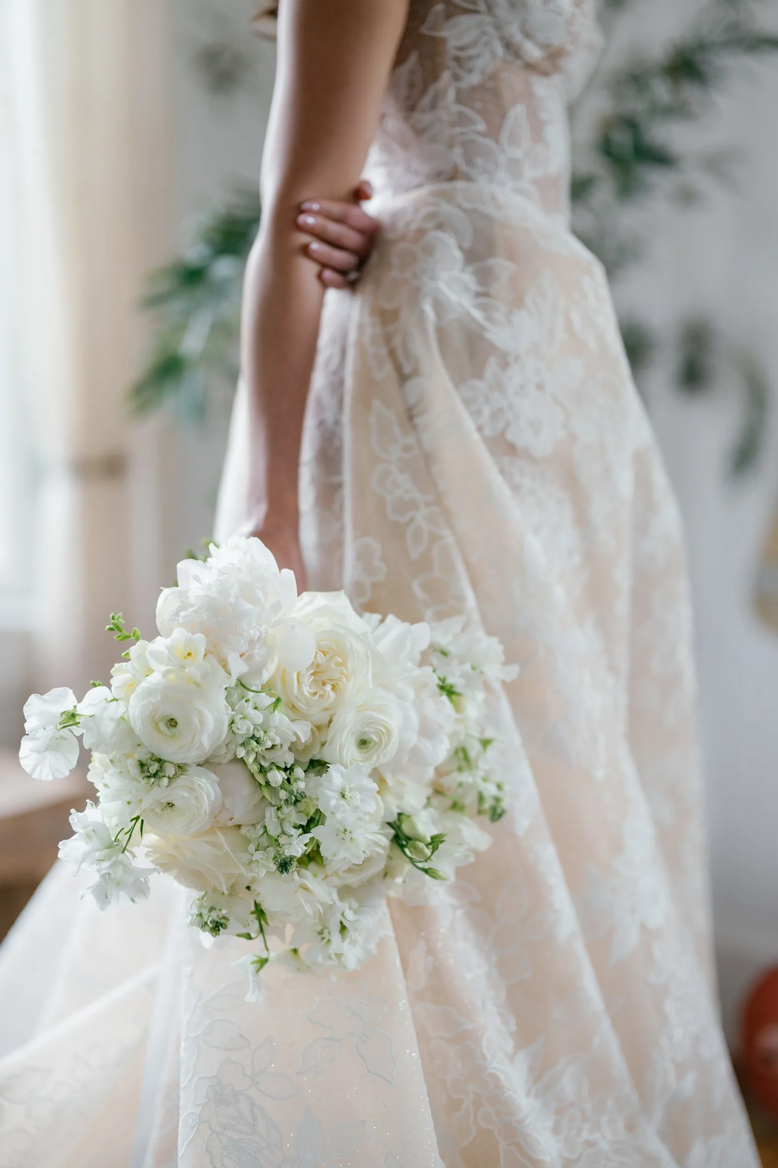 Detail of Kayla's lace gown and white bouquet