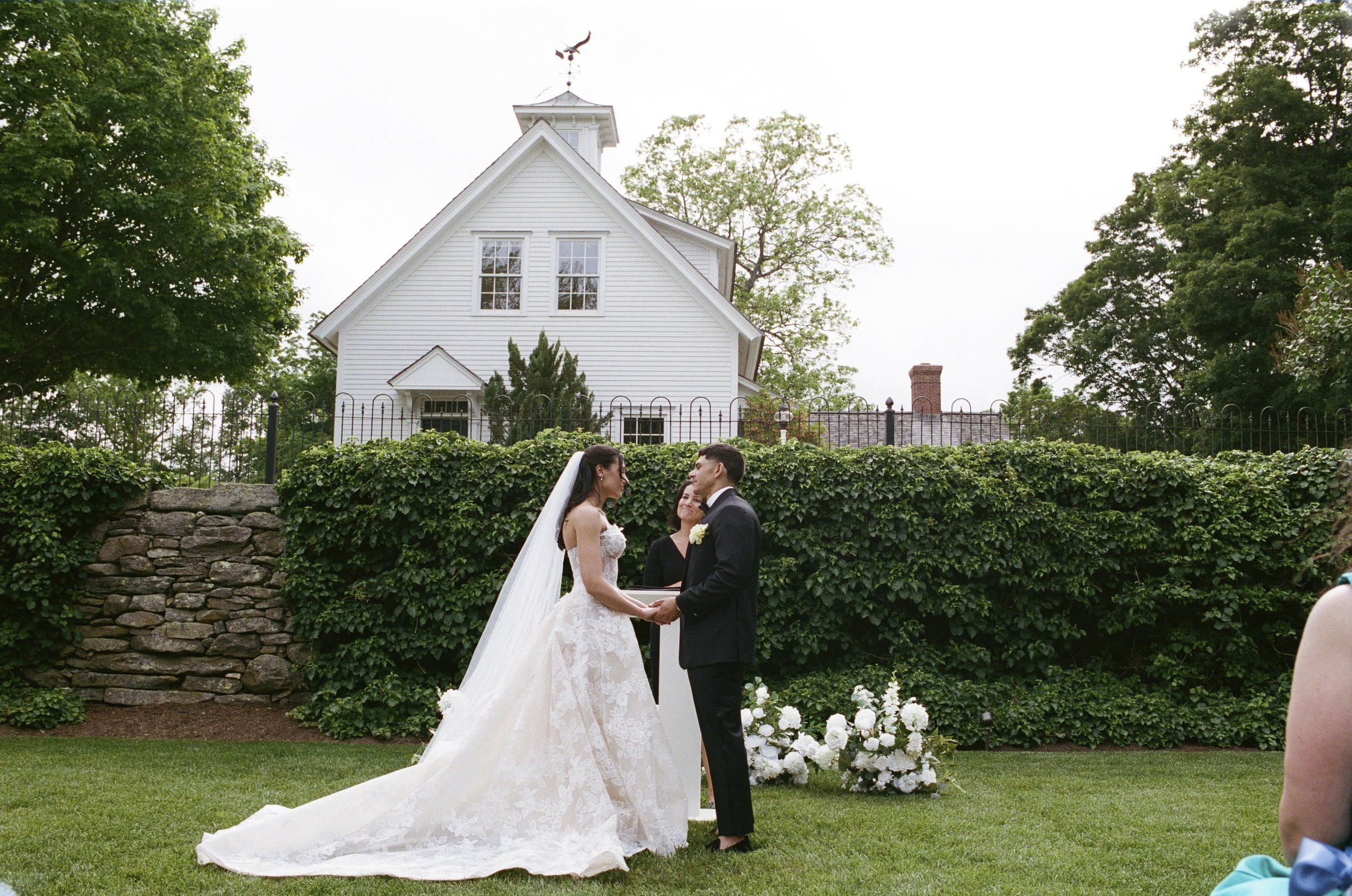 Kayla and Avery exchanging vows by the stone wall