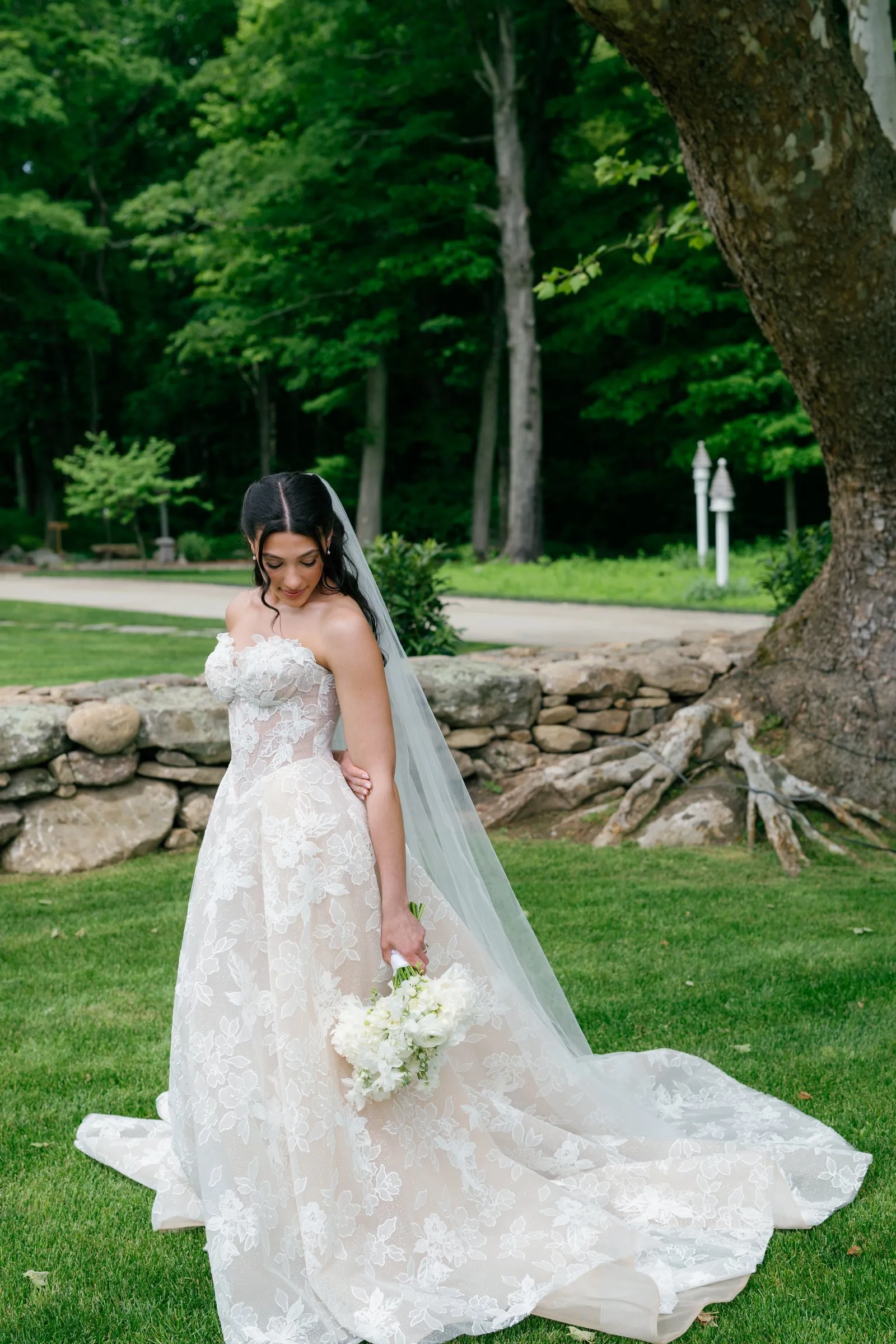 Kayla in her veil by the old stone wall and the sycamore