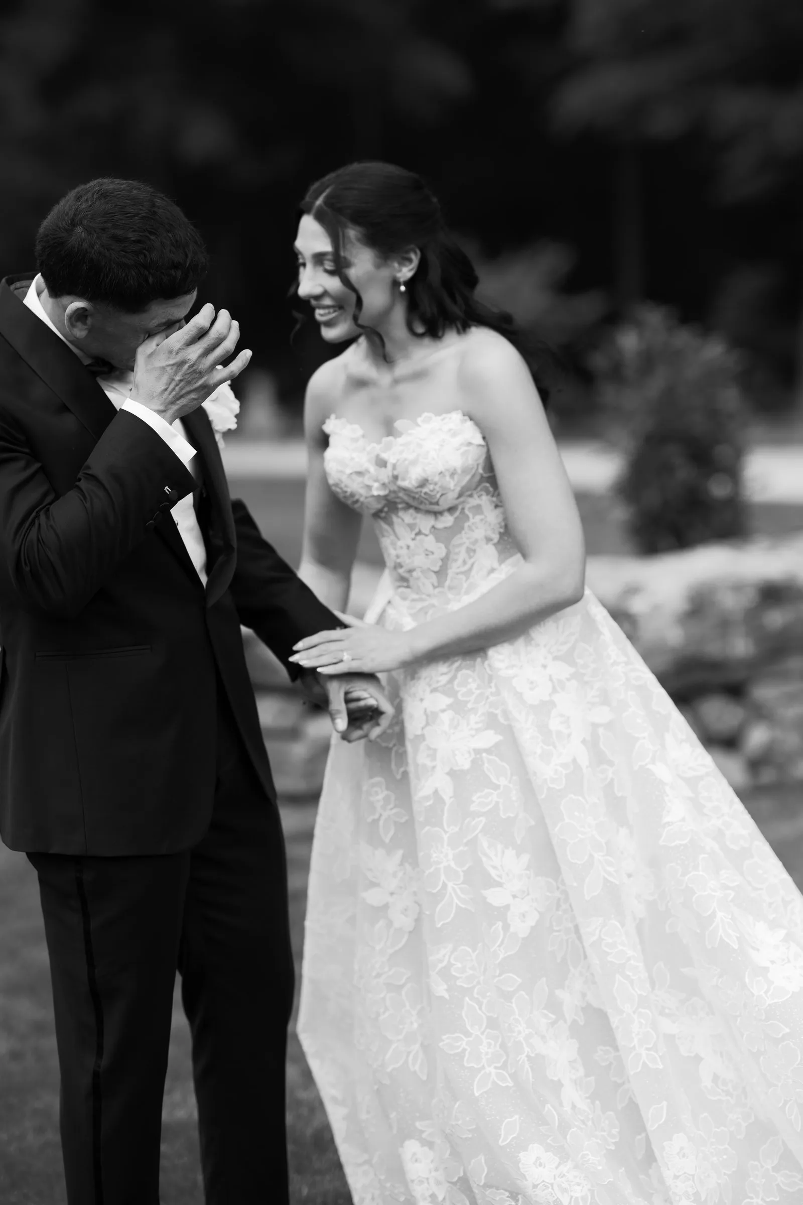 Avery wiping a tear as Kayla smiles at him, in black and white