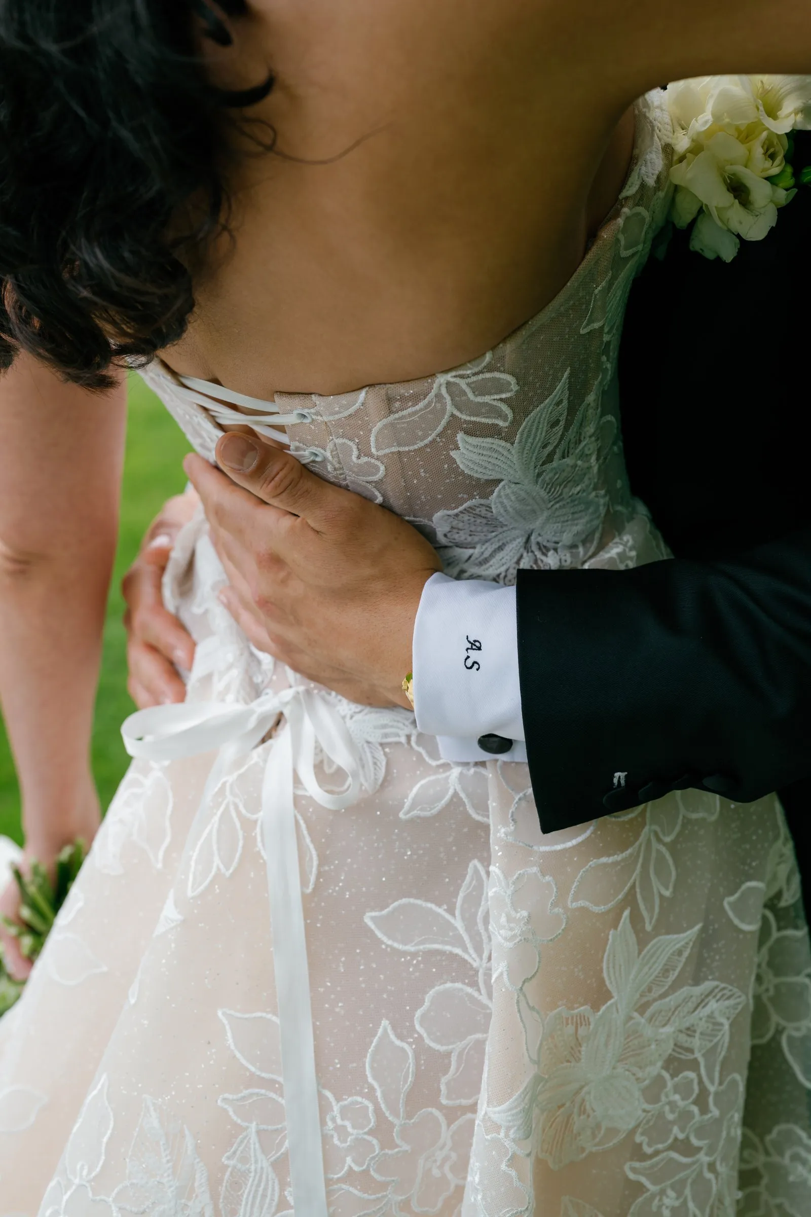 Avery's hand at the laced back of Kayla's gown