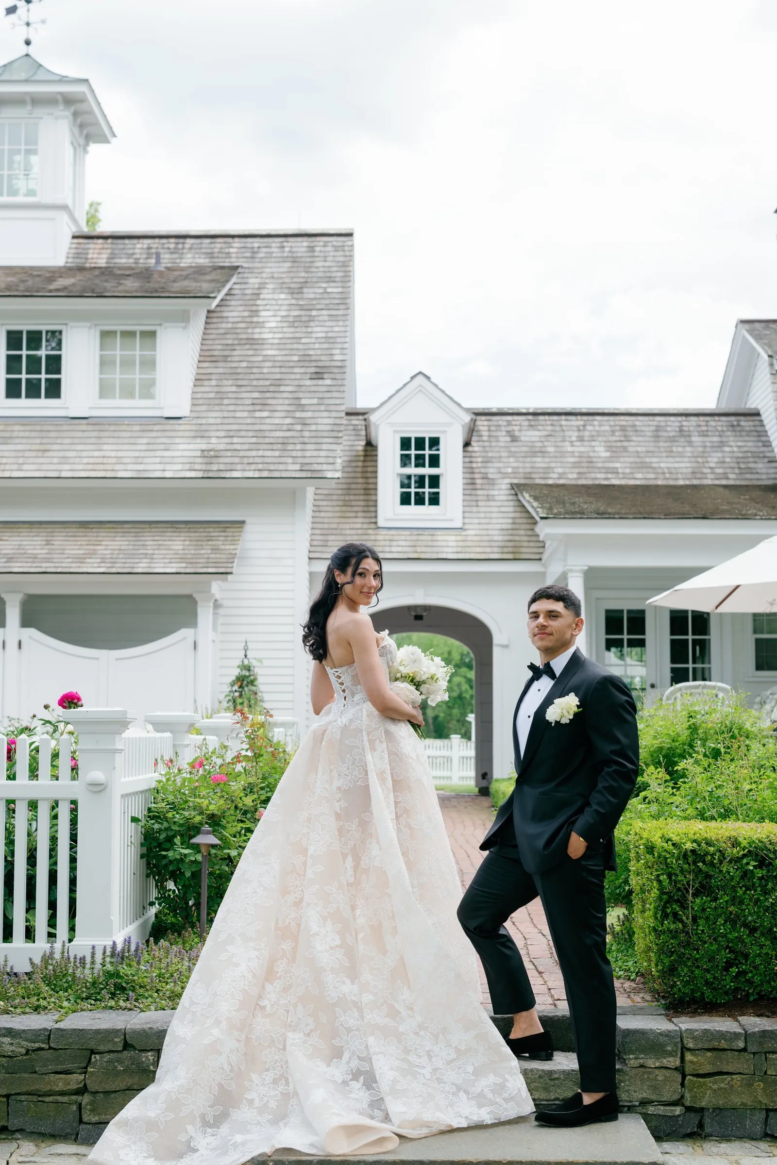 Kayla and Avery by the white picket fence in front of the house