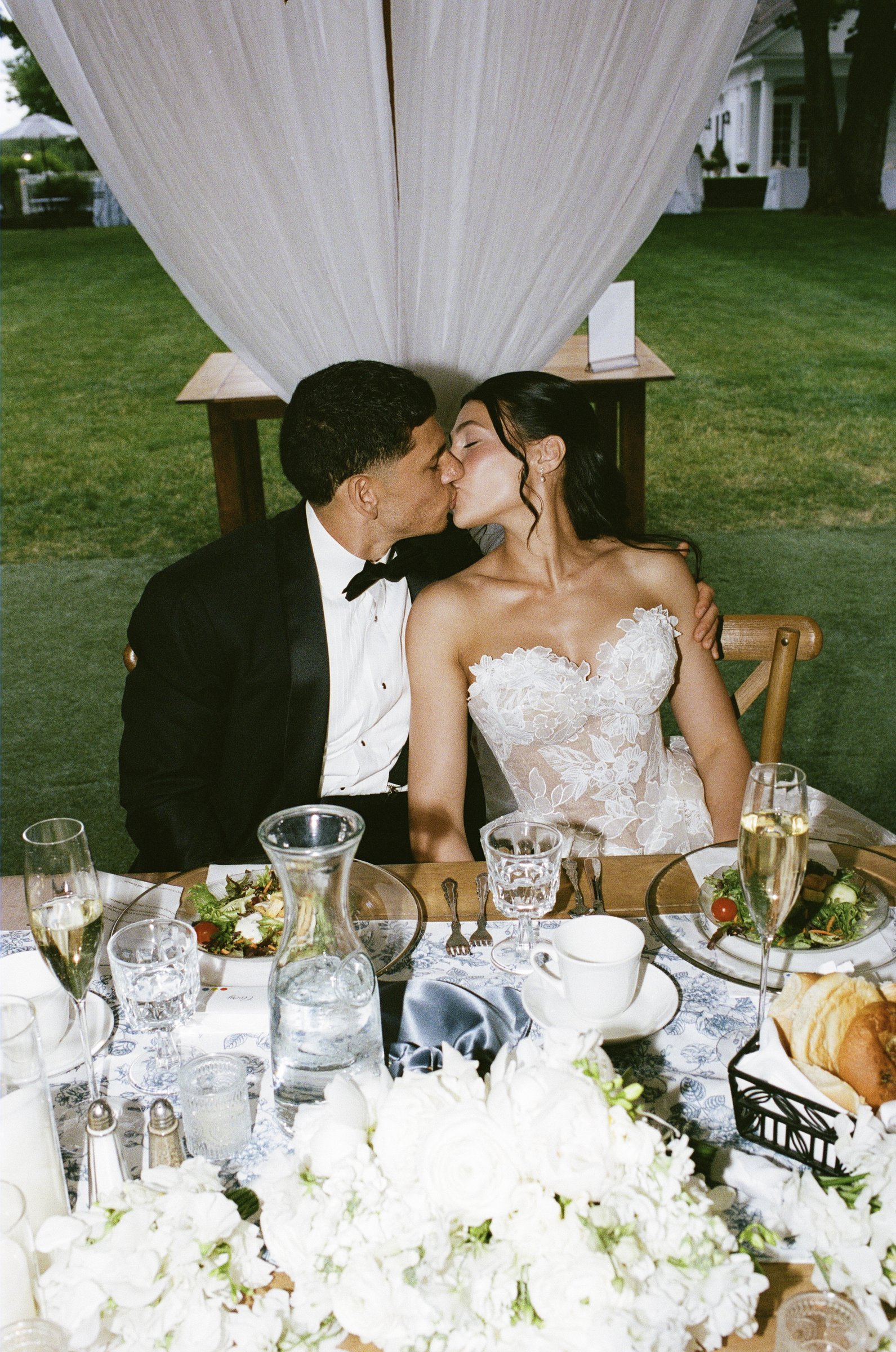 Kayla and Avery kissing at their sweetheart table