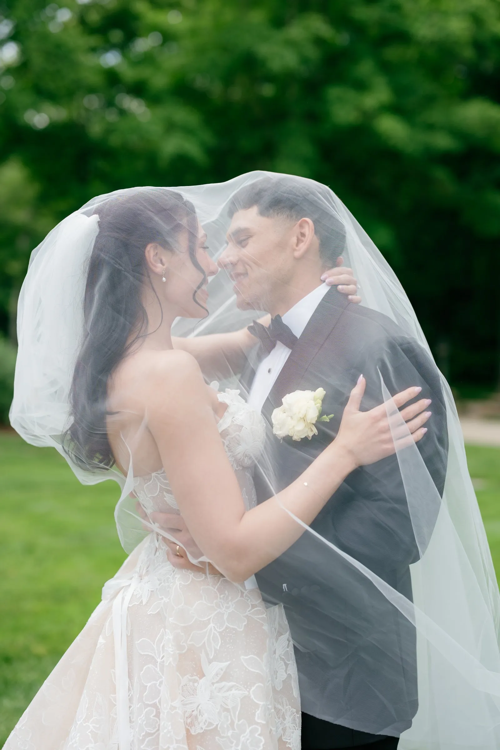 Kayla and Avery under her veil, close to a kiss