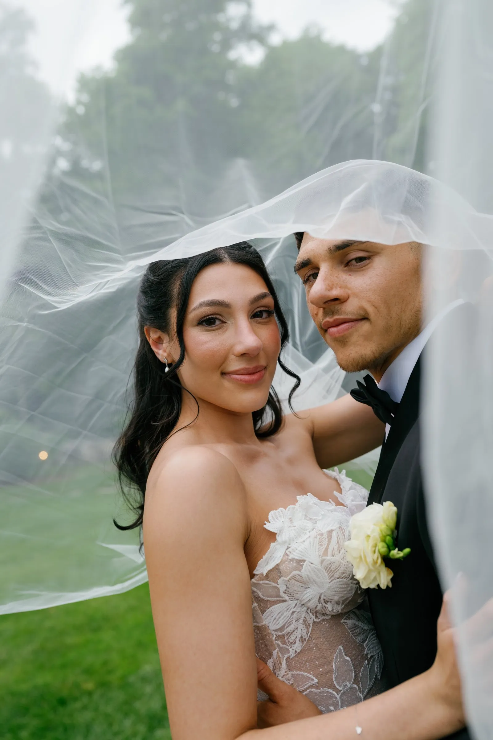 Kayla and Avery under her veil, looking at the camera