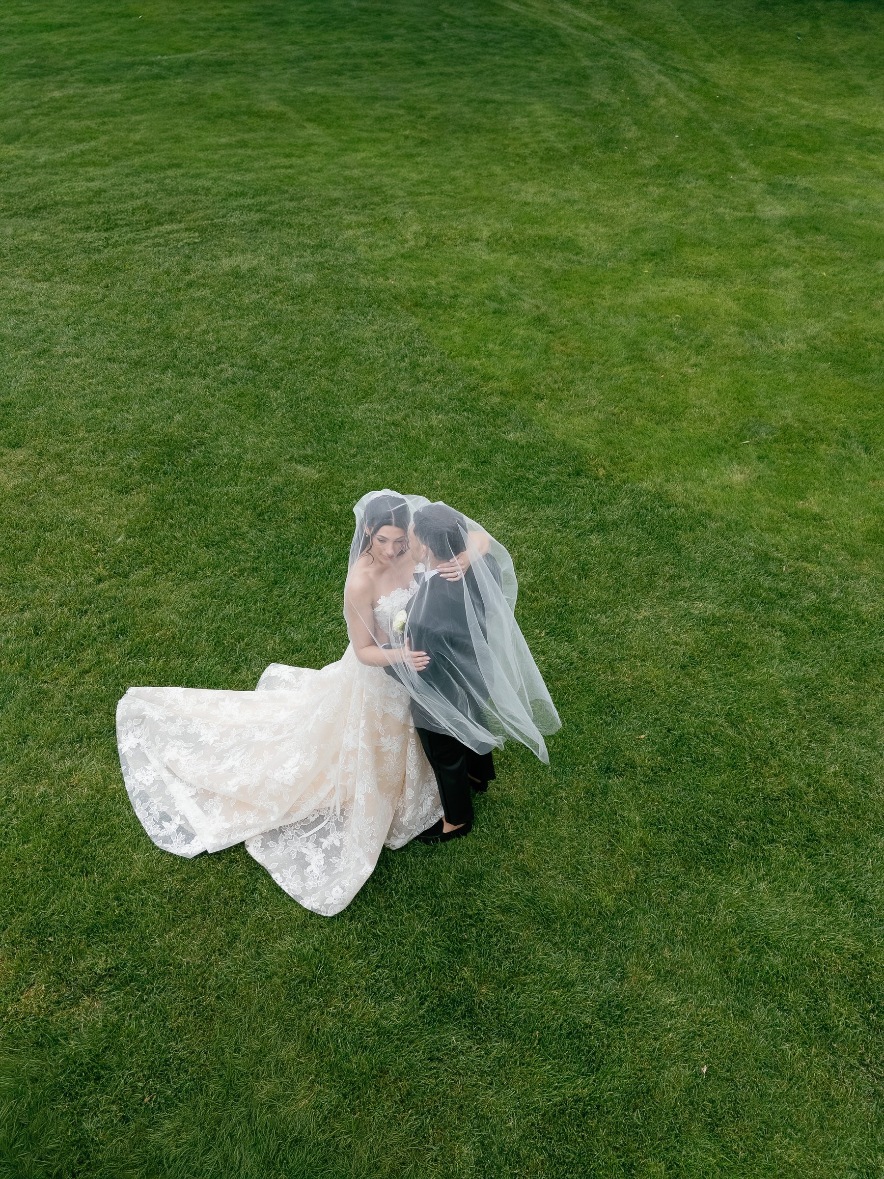 Kayla and Avery under her veil on the lawn, seen from above