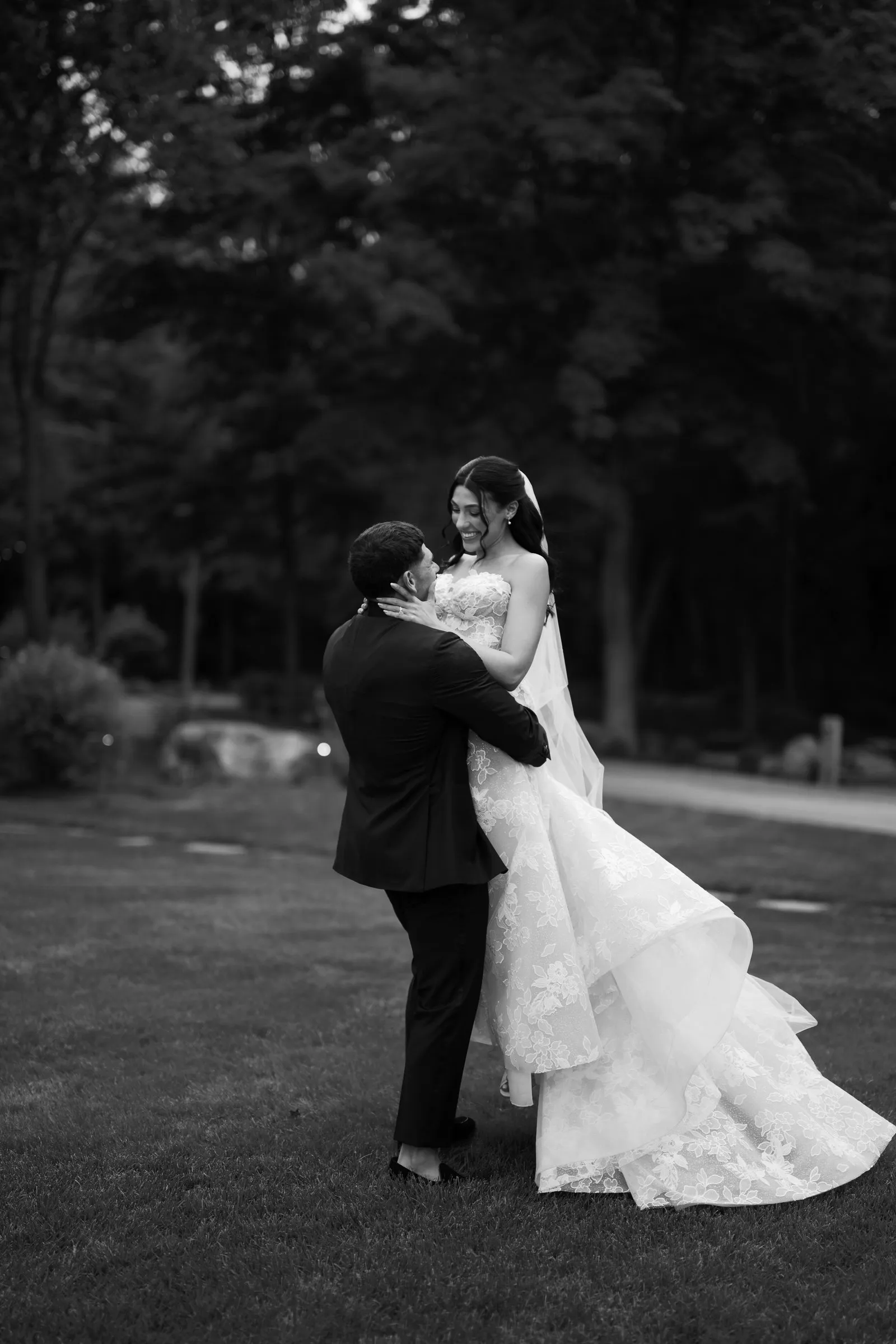Avery lifting Kayla on the lawn, in black and white
