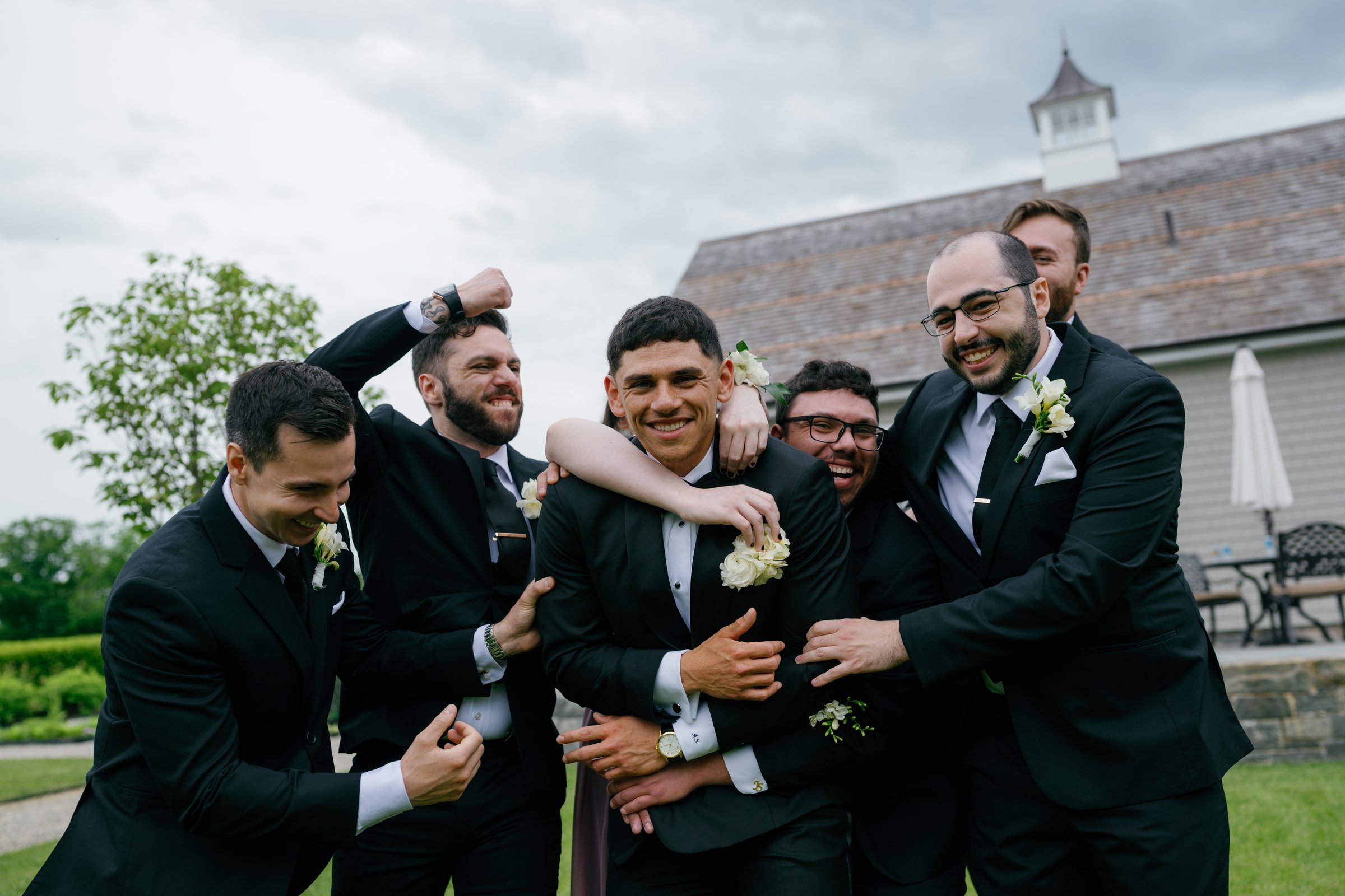 Avery's groomsmen piling in around him, laughing