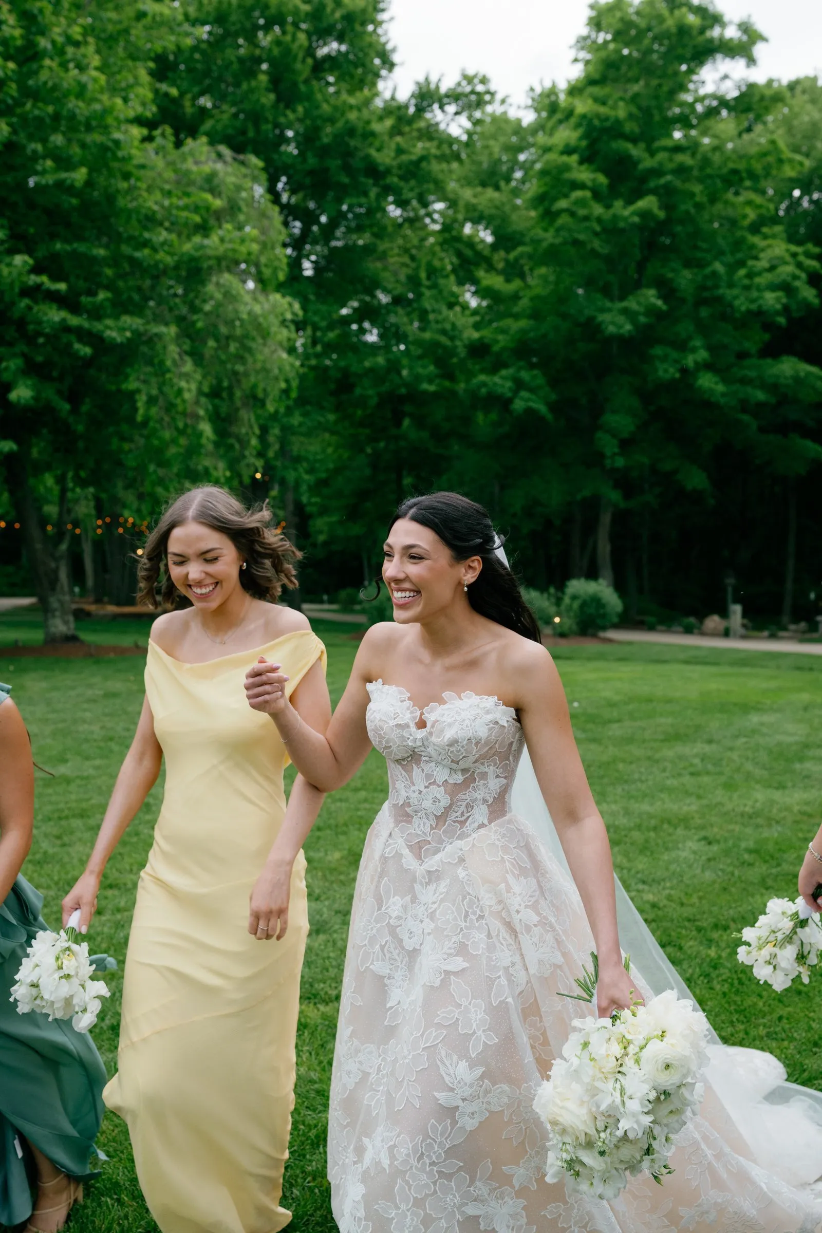 Kayla laughing as she walks with a bridesmaid in yellow