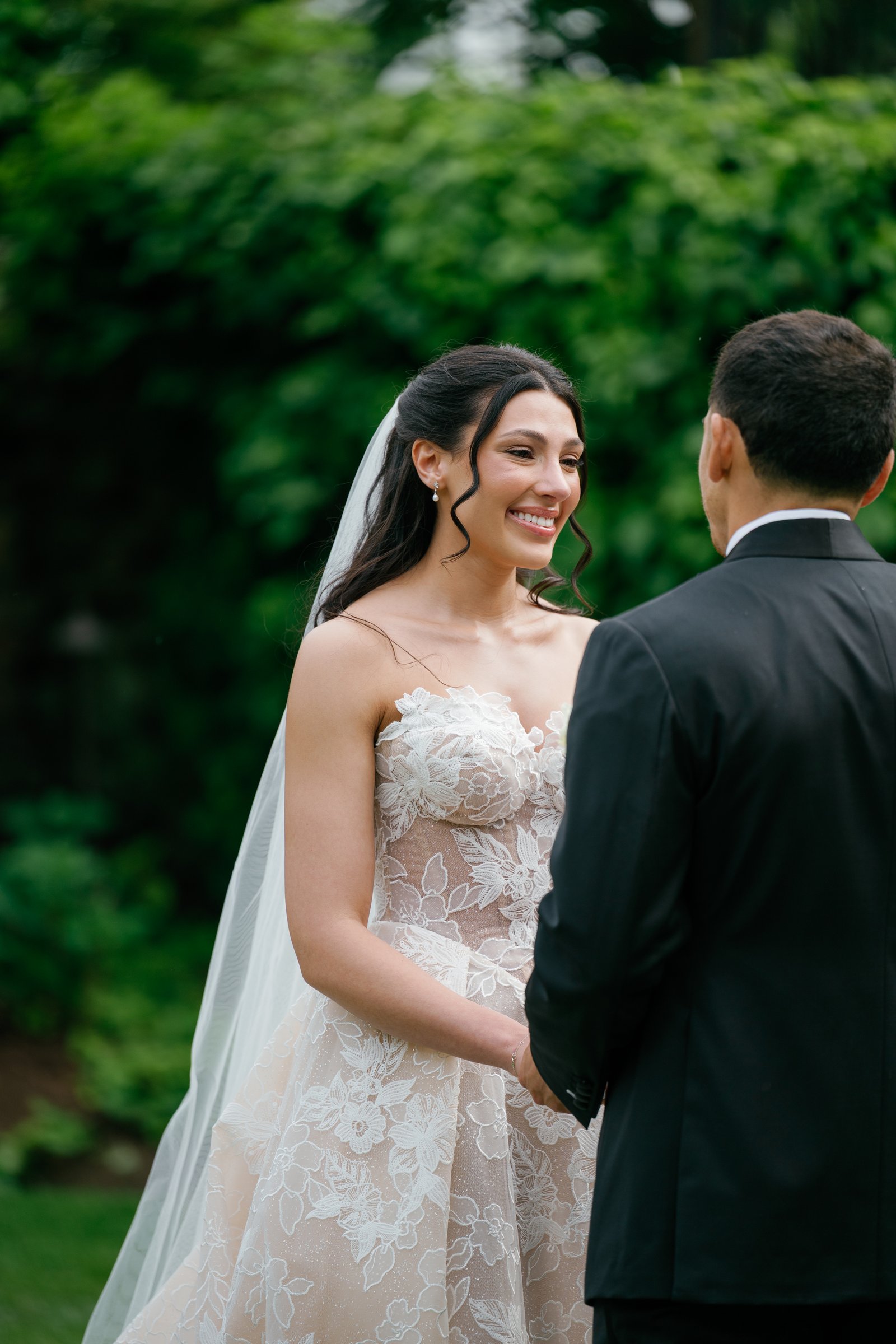 Kayla smiling at Avery as they hold hands at the altar