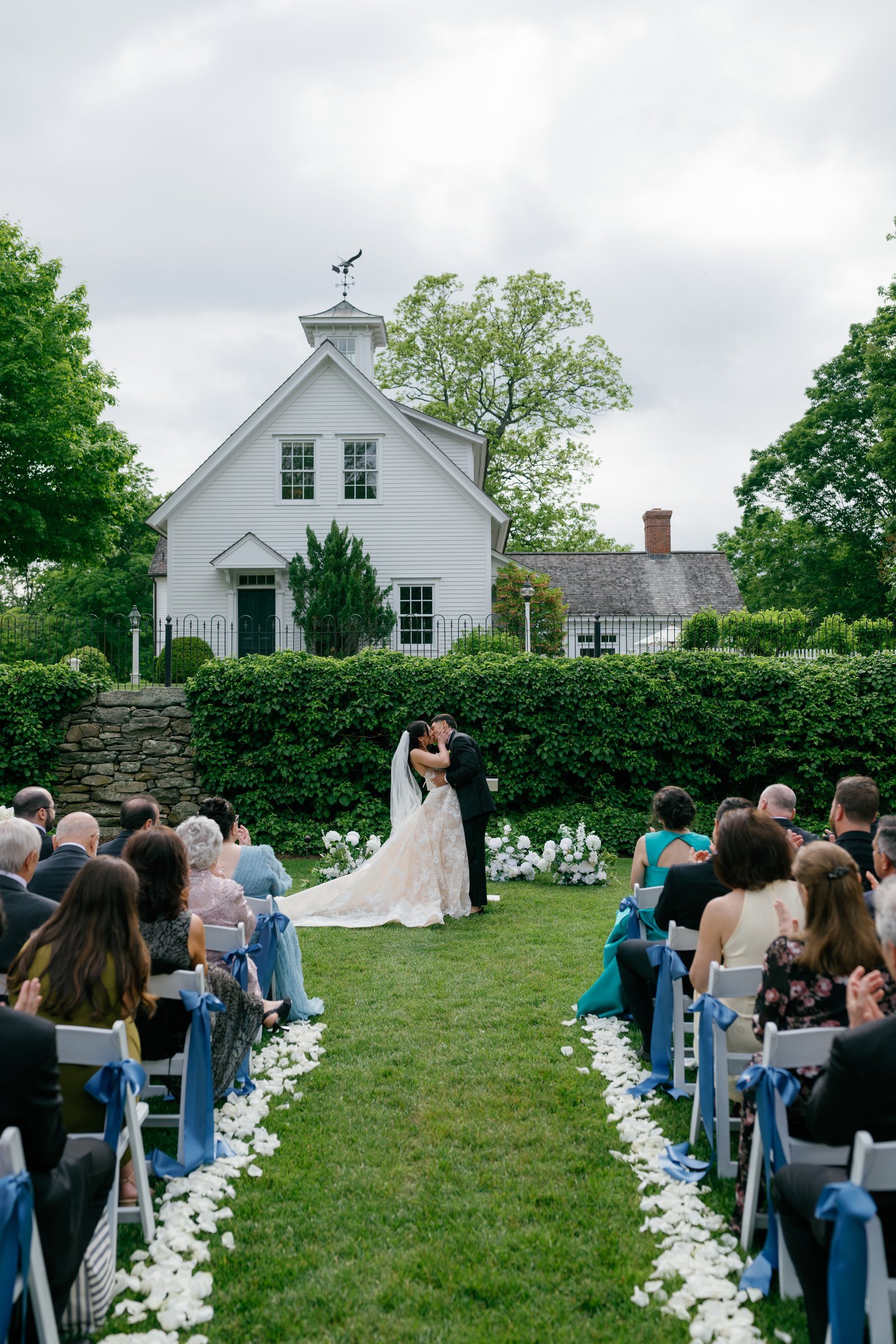 Kayla and Avery's first kiss, seen down the aisle with the white chapel behind