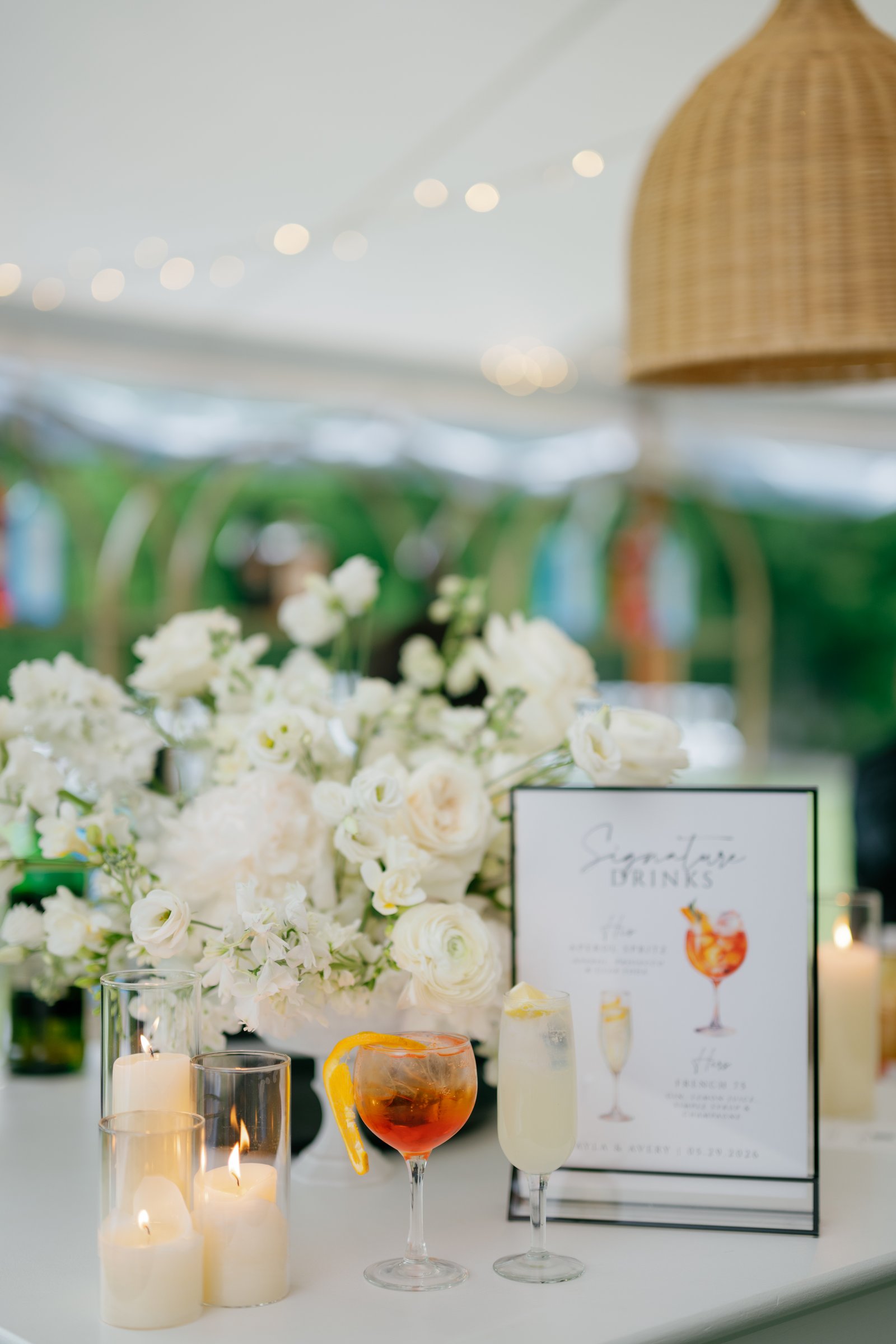 The signature cocktail menu with white flowers and candles