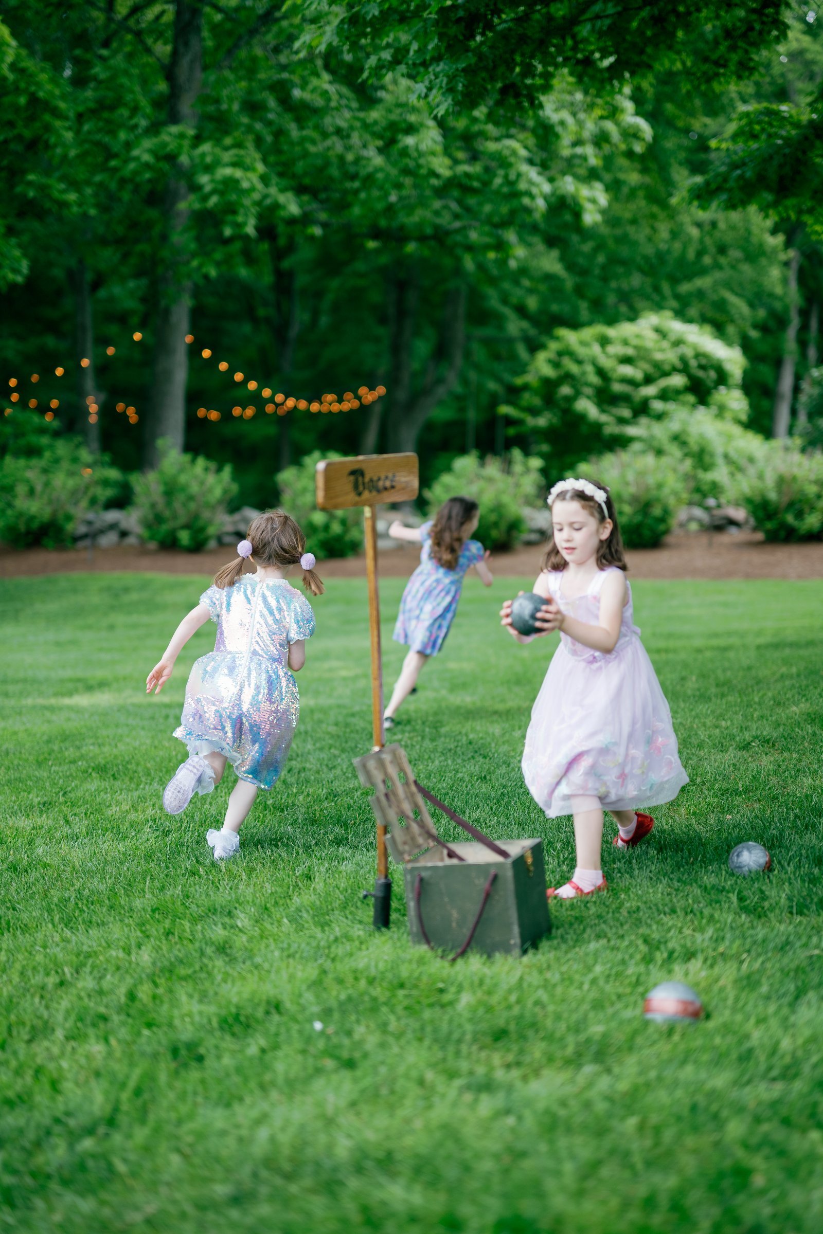 Two flower girls running across the lawn at cocktail hour