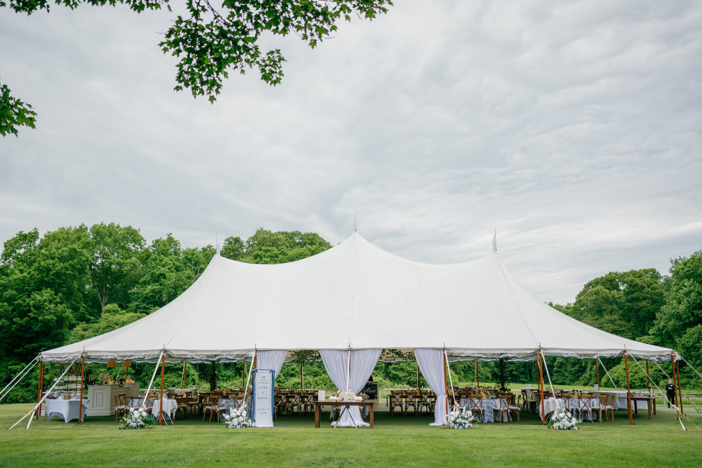 The sailcloth tent in the meadow with the trees behind
