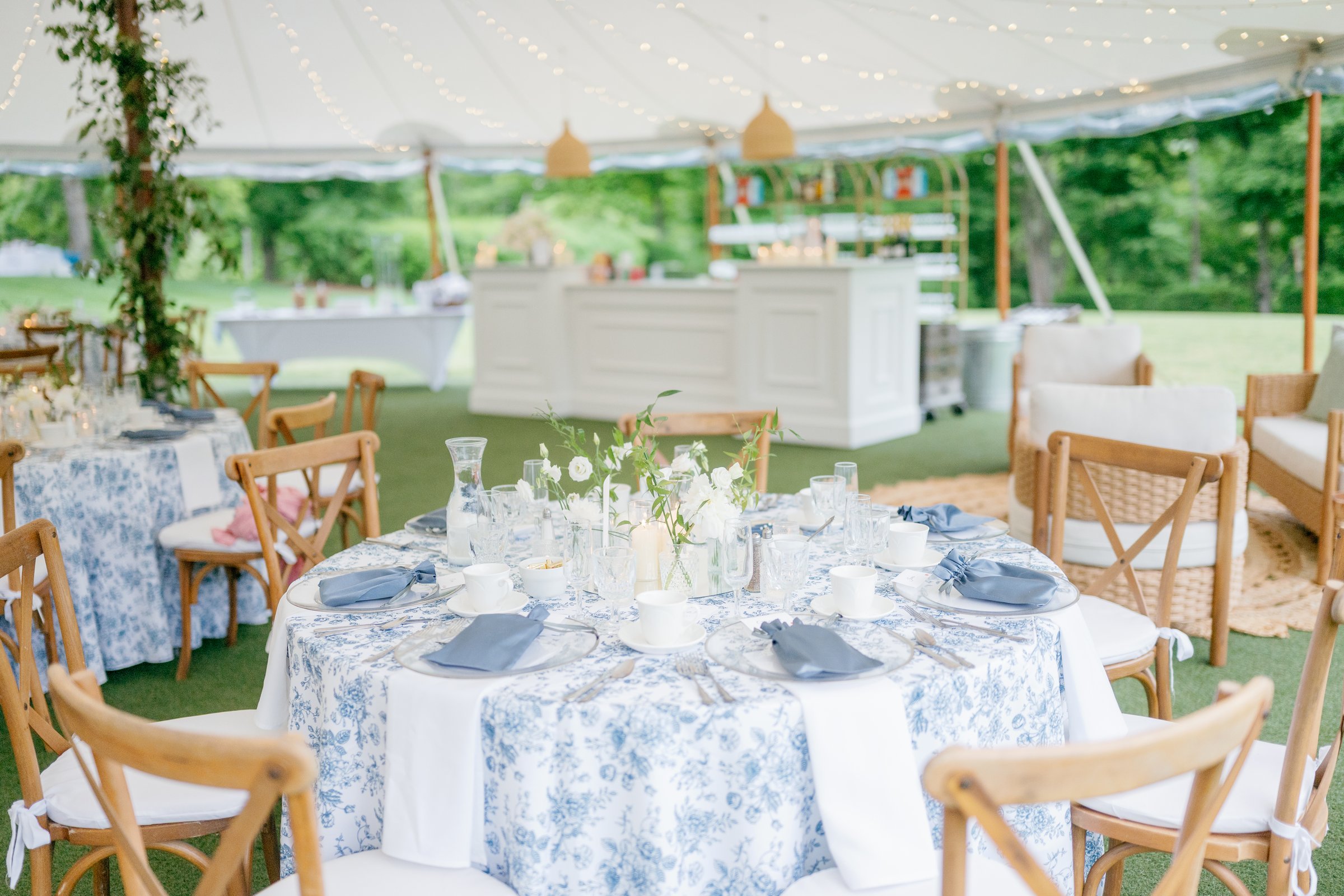 A round table set in blue toile linen with white flowers