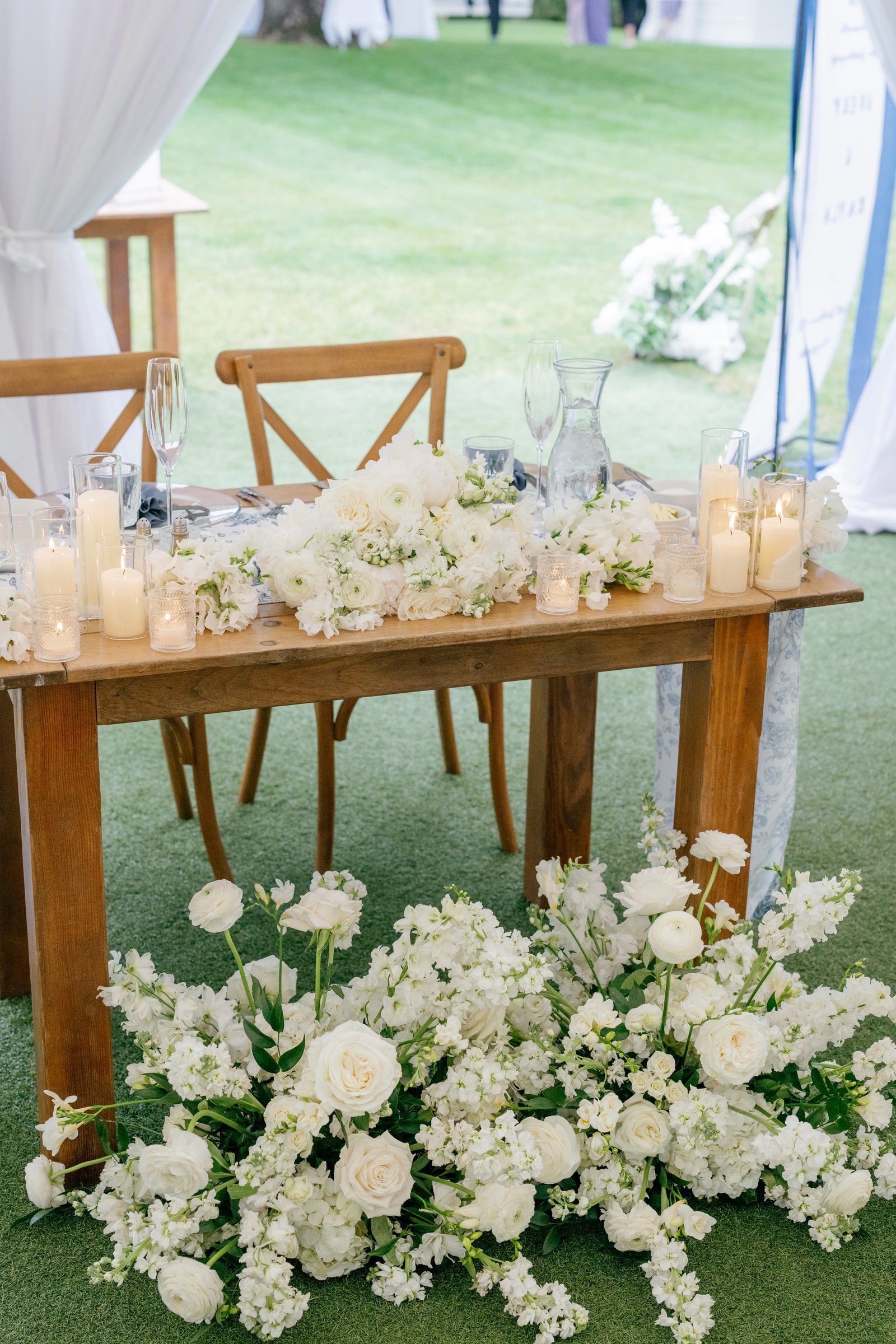 The sweetheart table with candles and white flowers