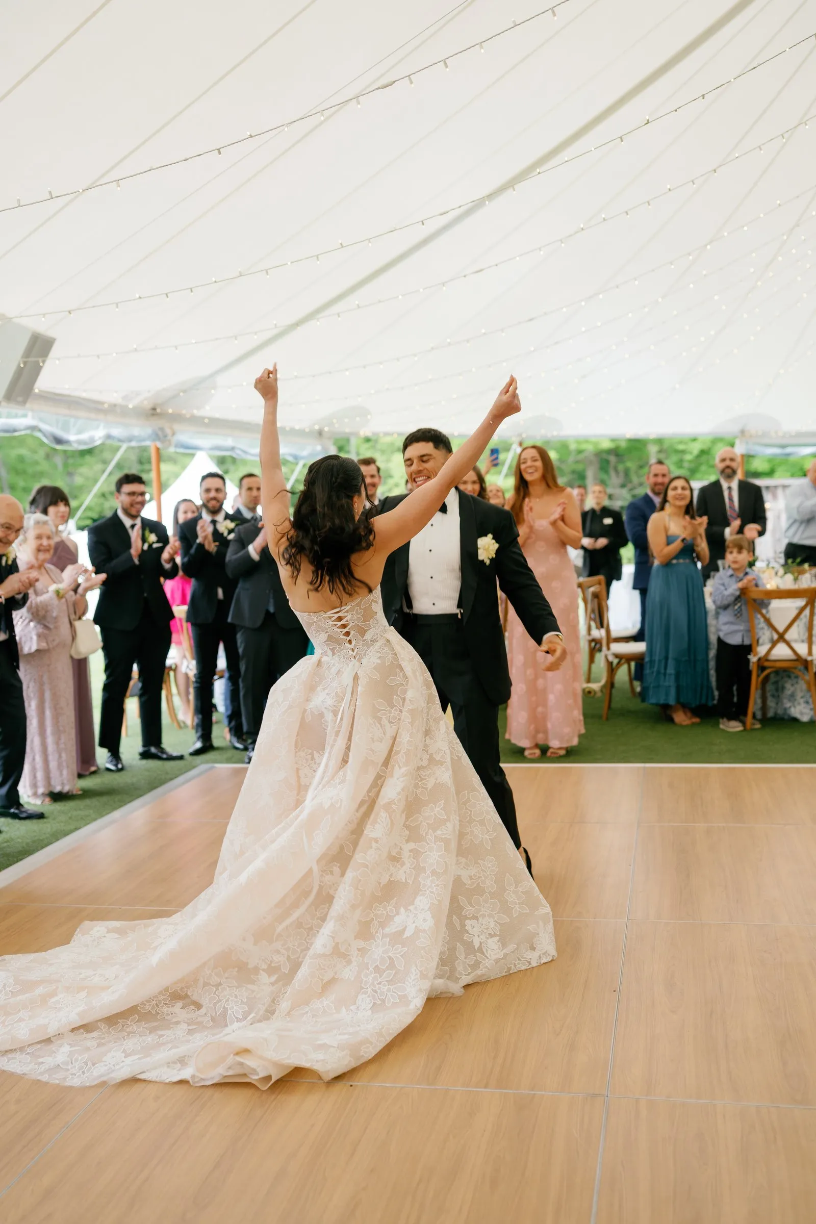 Kayla and Avery throwing their arms up as they enter the tent