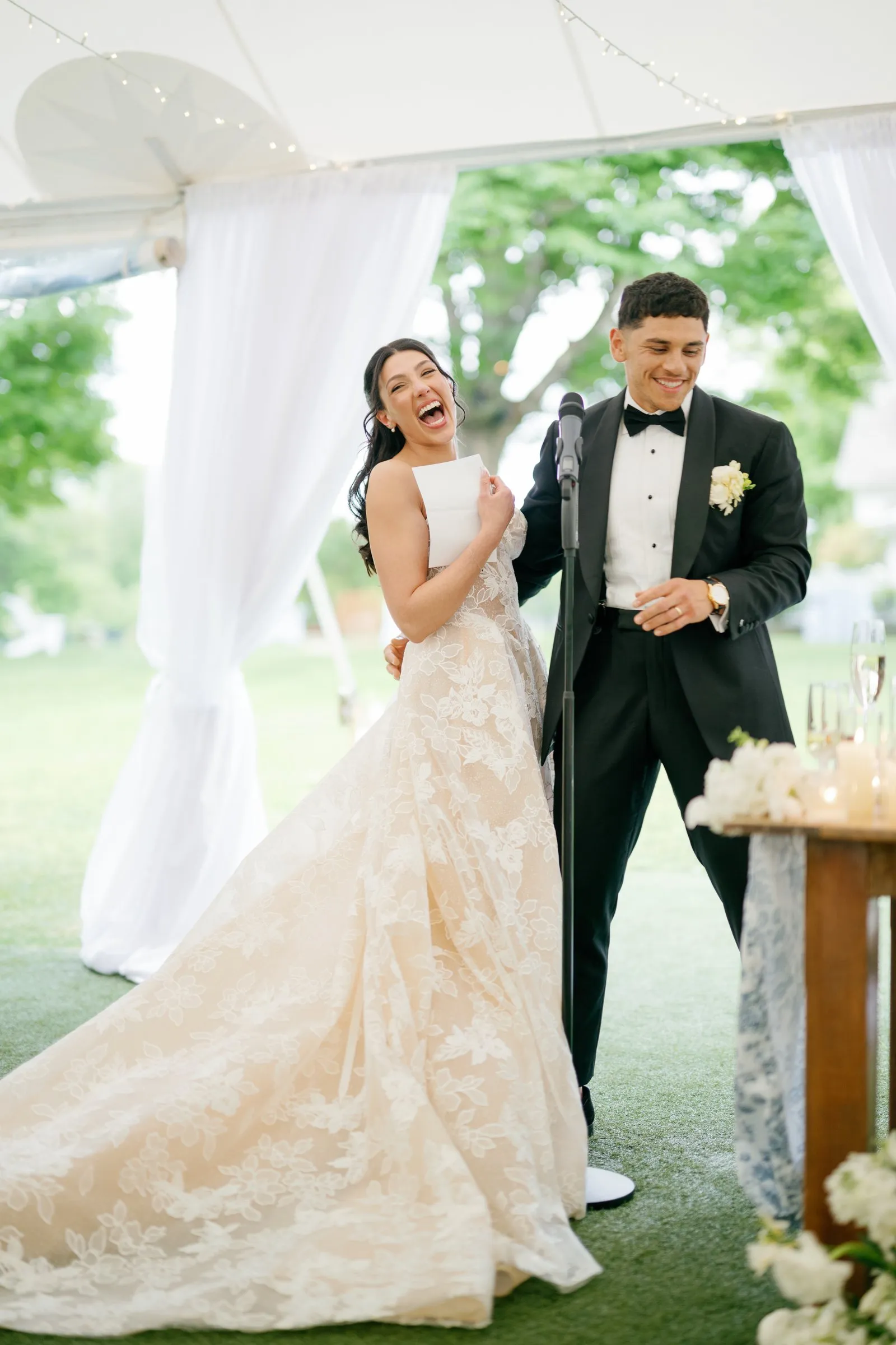 Kayla laughing as Avery gives a toast