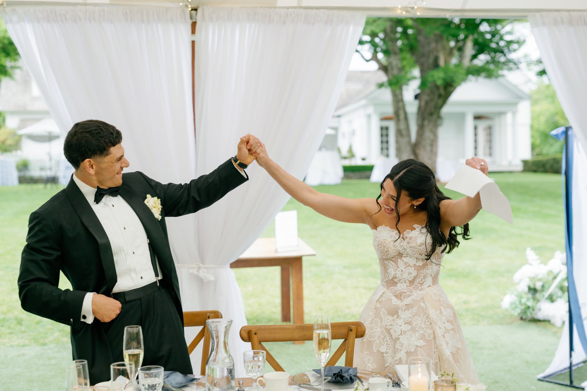 Kayla and Avery raising their arms at the sweetheart table