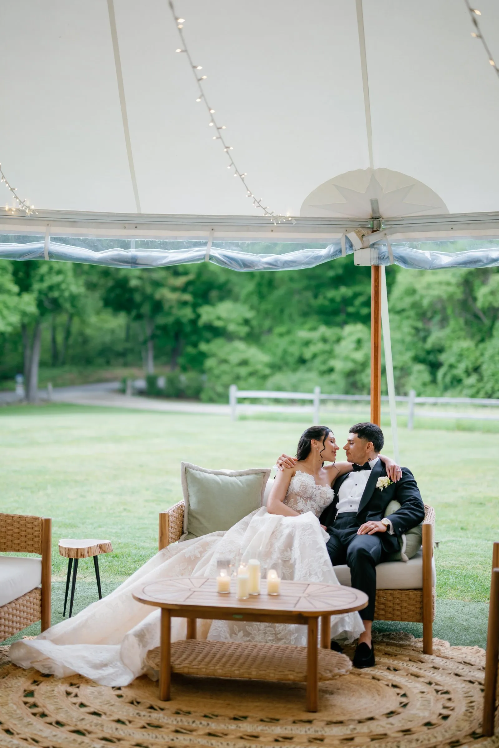 Kayla and Avery kissing on the lounge sofa beside the tent