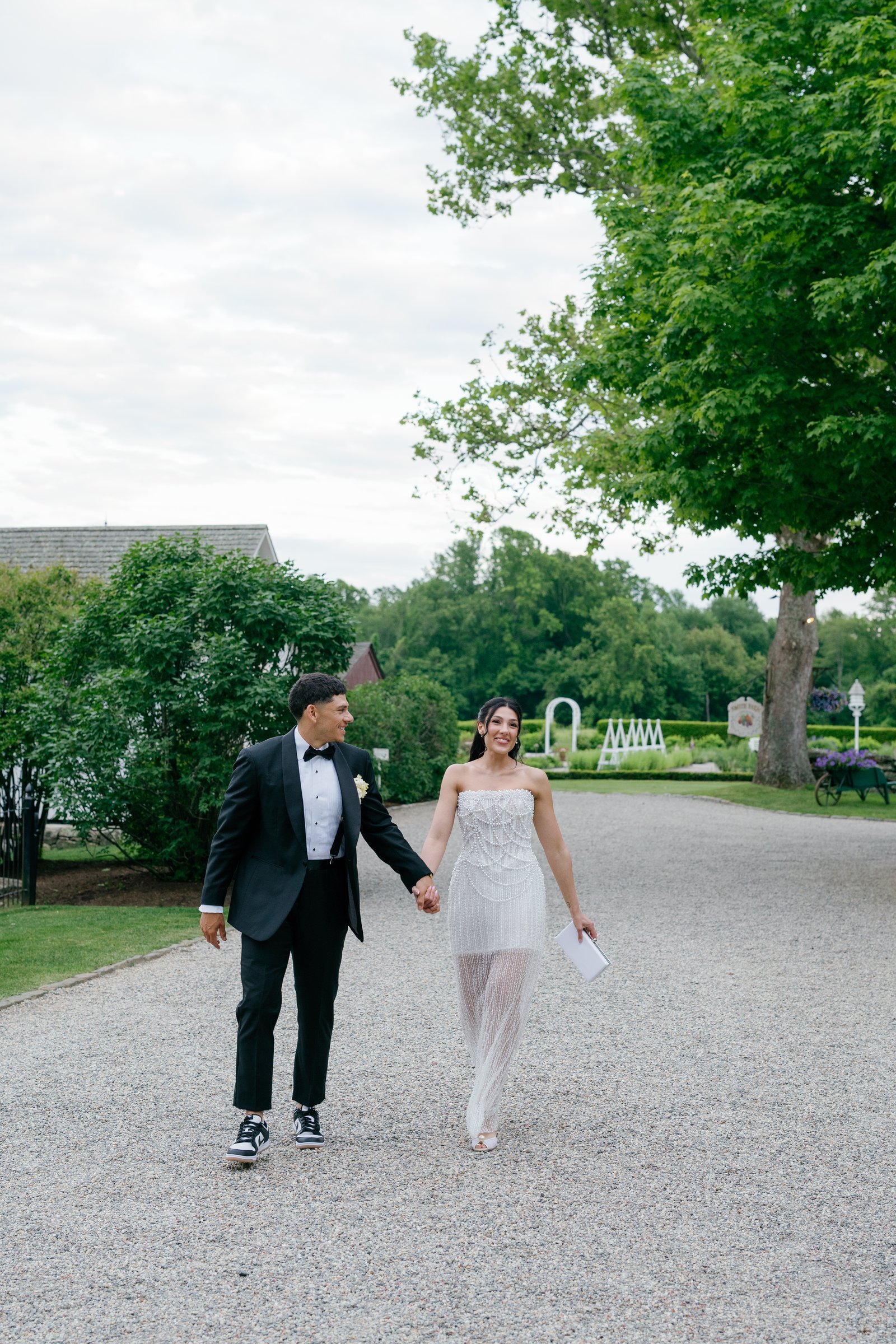 Kayla and Avery walking up the gravel drive, Kayla in her second dress