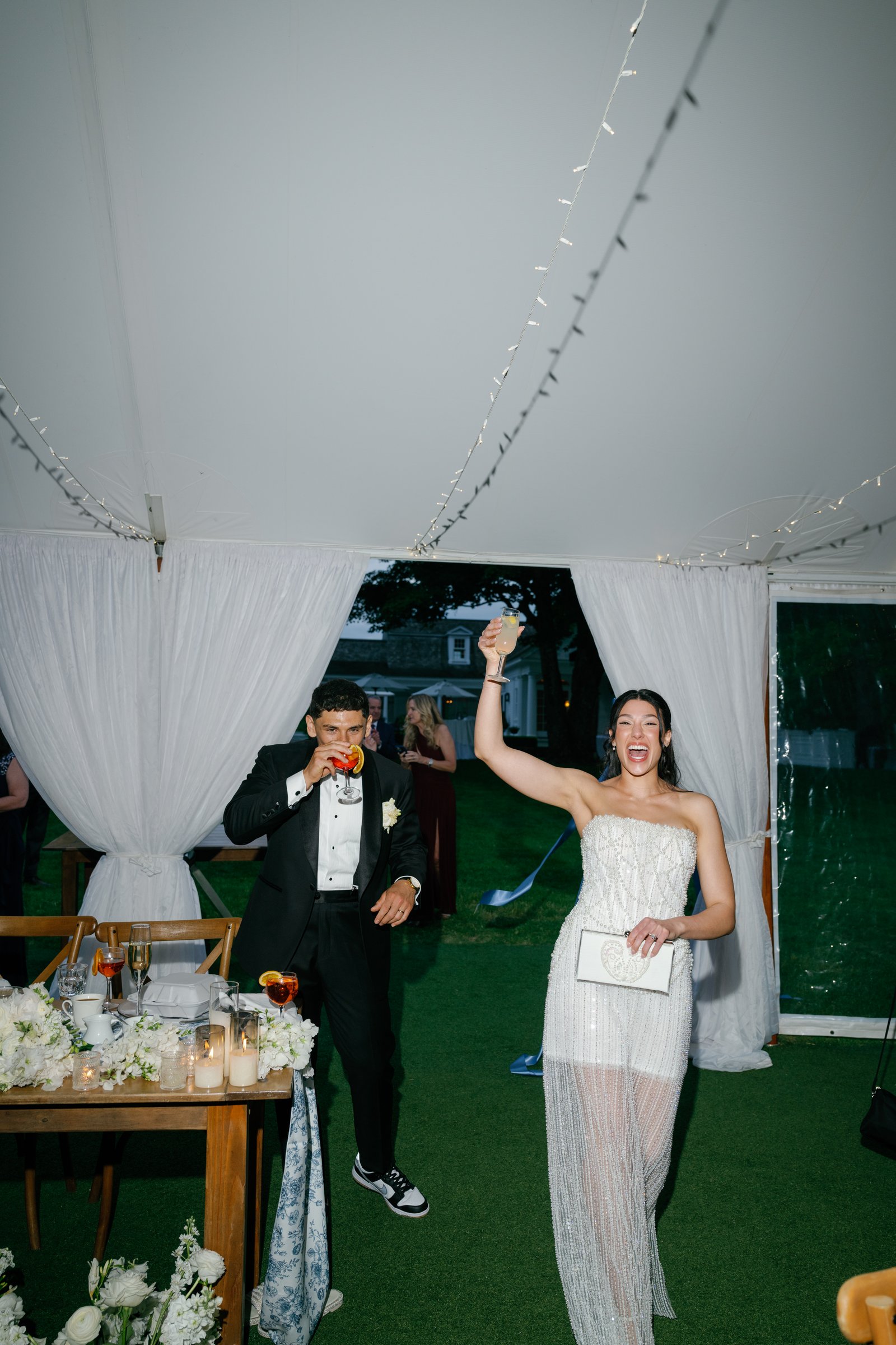 Kayla and Avery coming back into the tent, Kayla raising her arm as guests cheer
