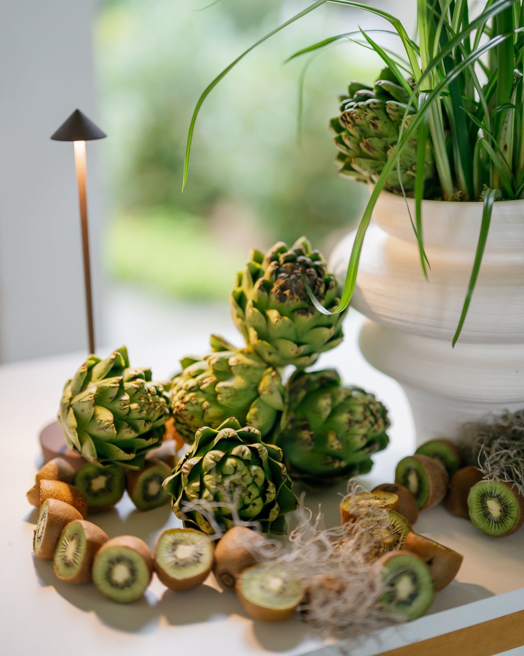 Artichokes and kiwi arranged as a still life. Photographed by Shukhrat Kamalov.