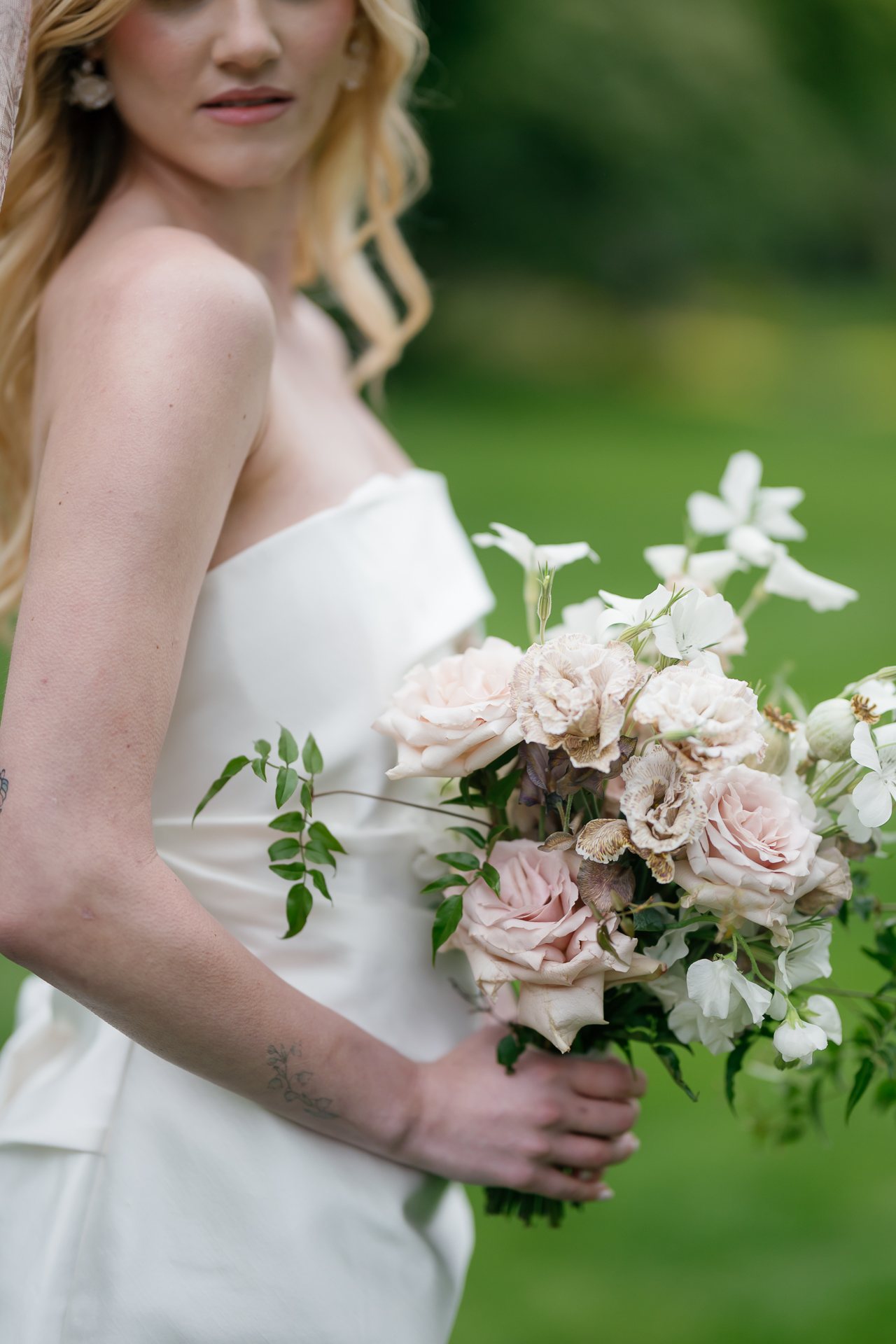Bride holding a blush and white bouquet of roses and jasmine. Photographed by Shukhrat Kamalov.