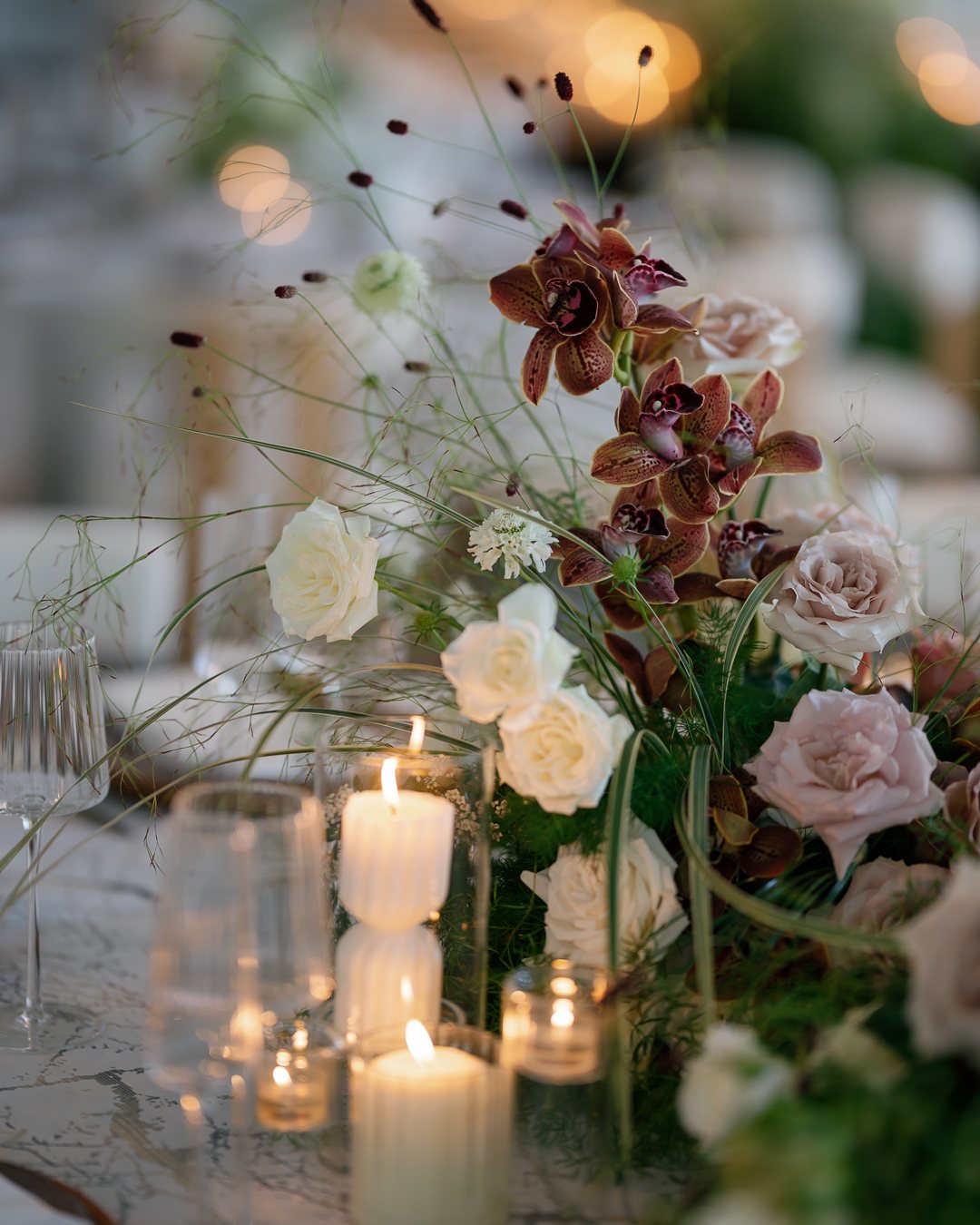 Candles with burgundy and blush flowers. Photographed by Shukhrat Kamalov.