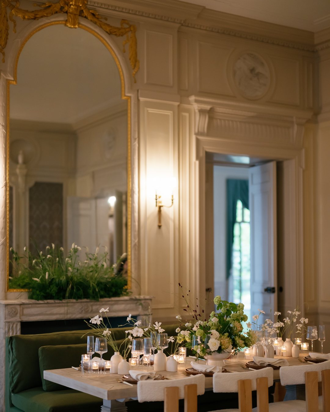 Dining room table set beneath a gilded mirror. Photographed by Shukhrat Kamalov.