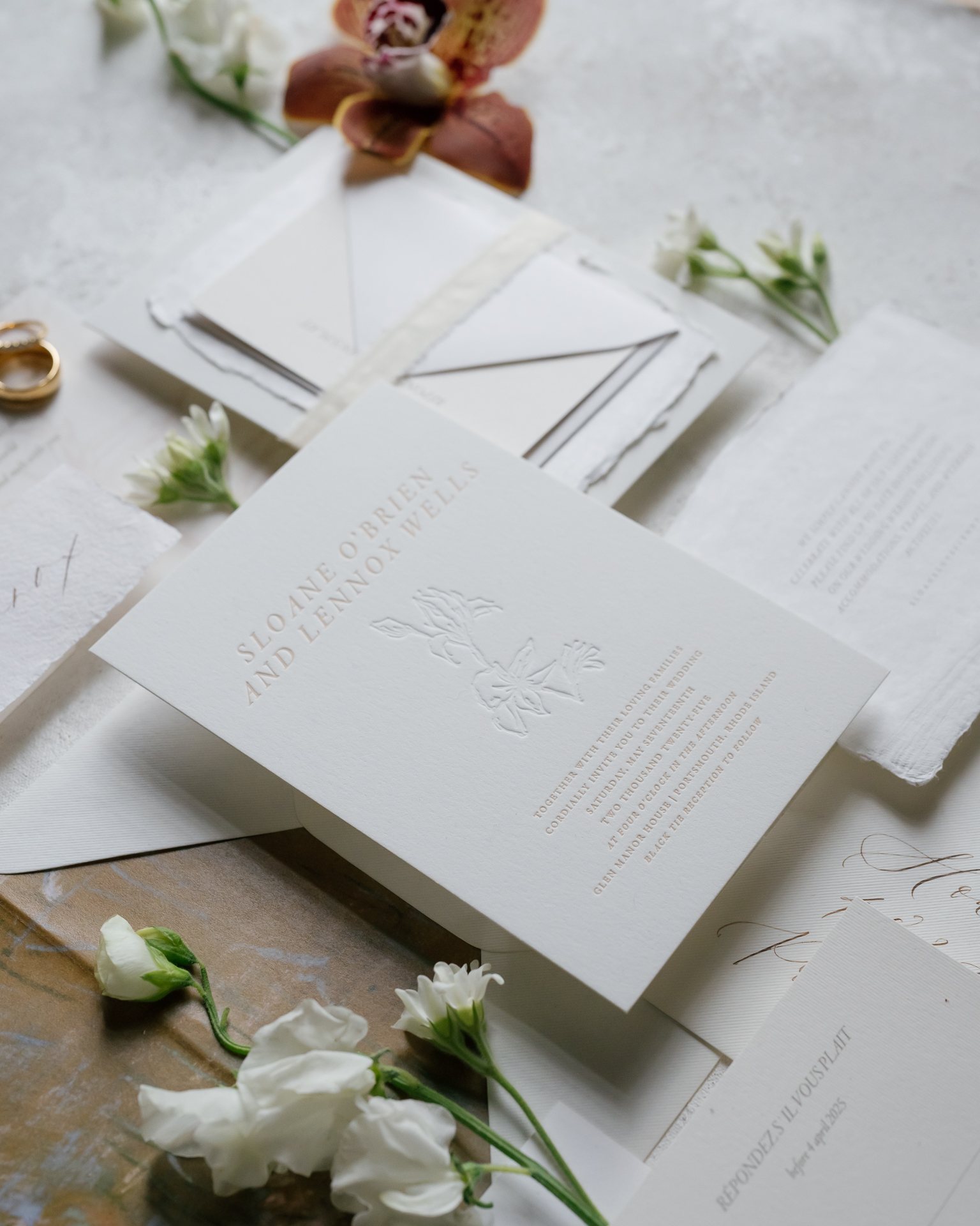 Letterpress invitation detail with white flowers. Photographed by Shukhrat Kamalov.