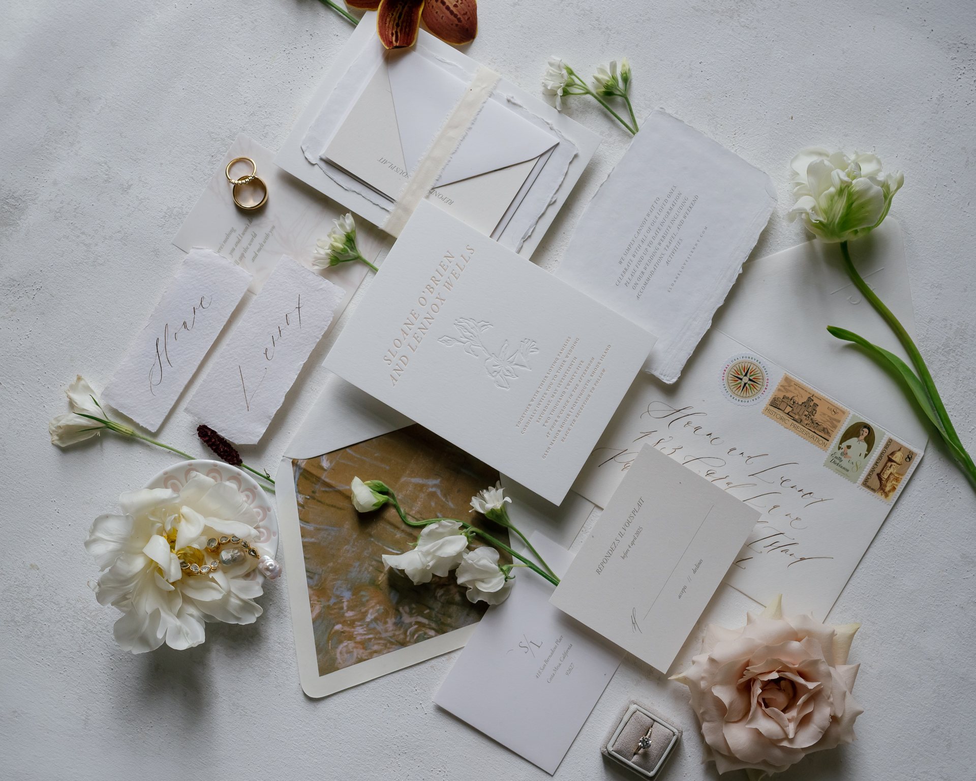 Wedding invitation suite with white blooms on linen. Photographed by Shukhrat Kamalov.