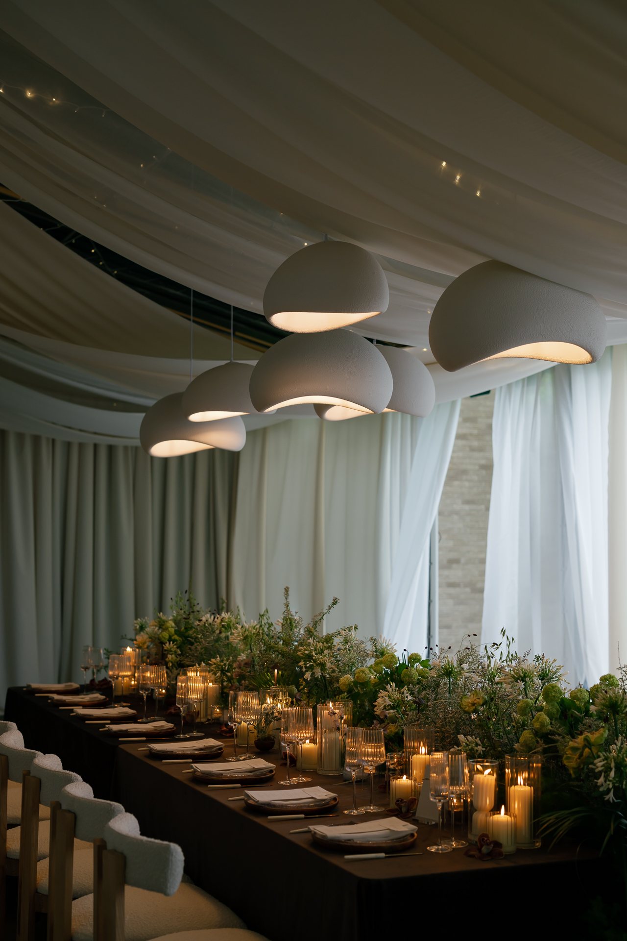 Long dinner table glowing with candlelight. Photographed by Shukhrat Kamalov.