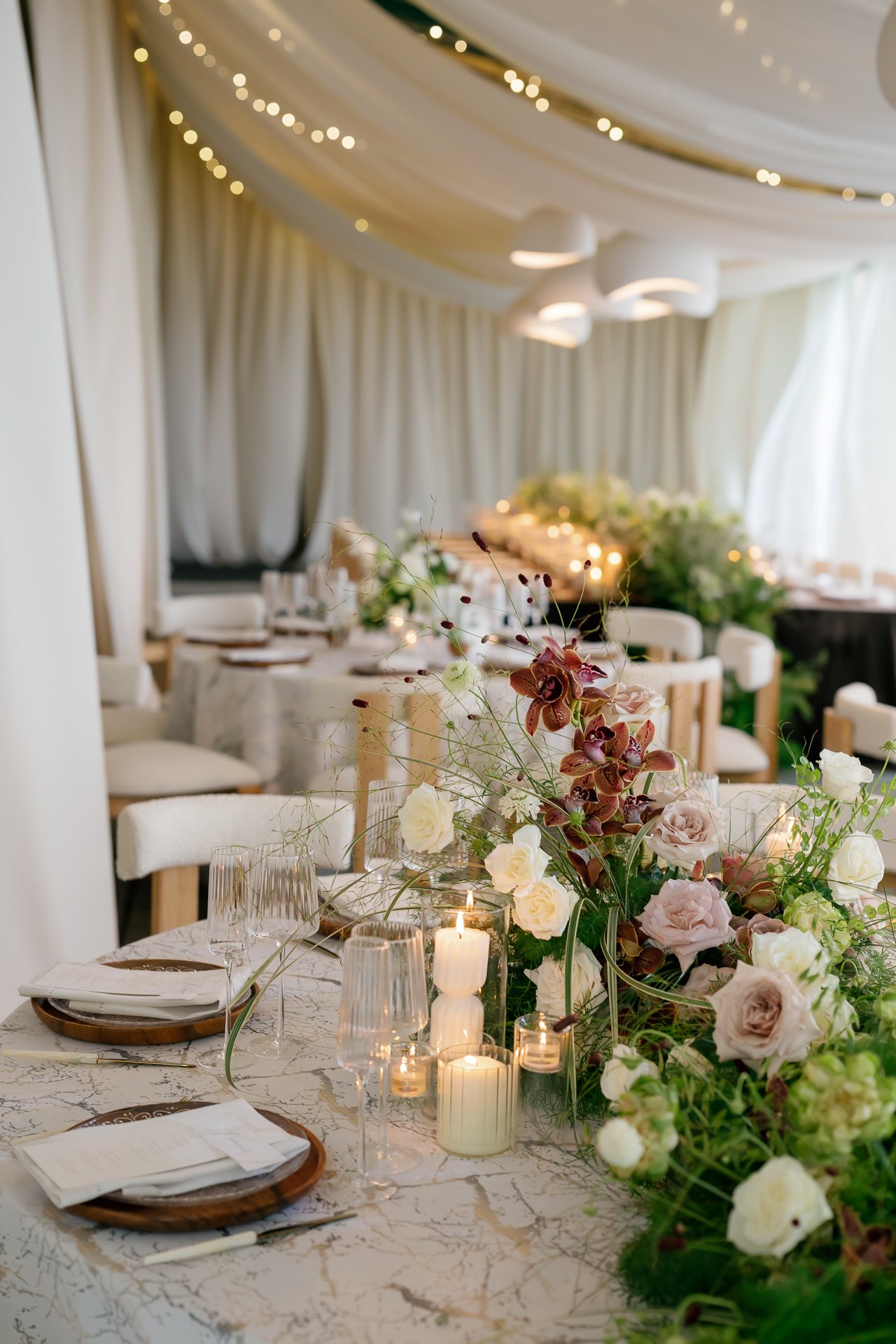 Long table with green and white florals in the tent. Photographed by Shukhrat Kamalov.