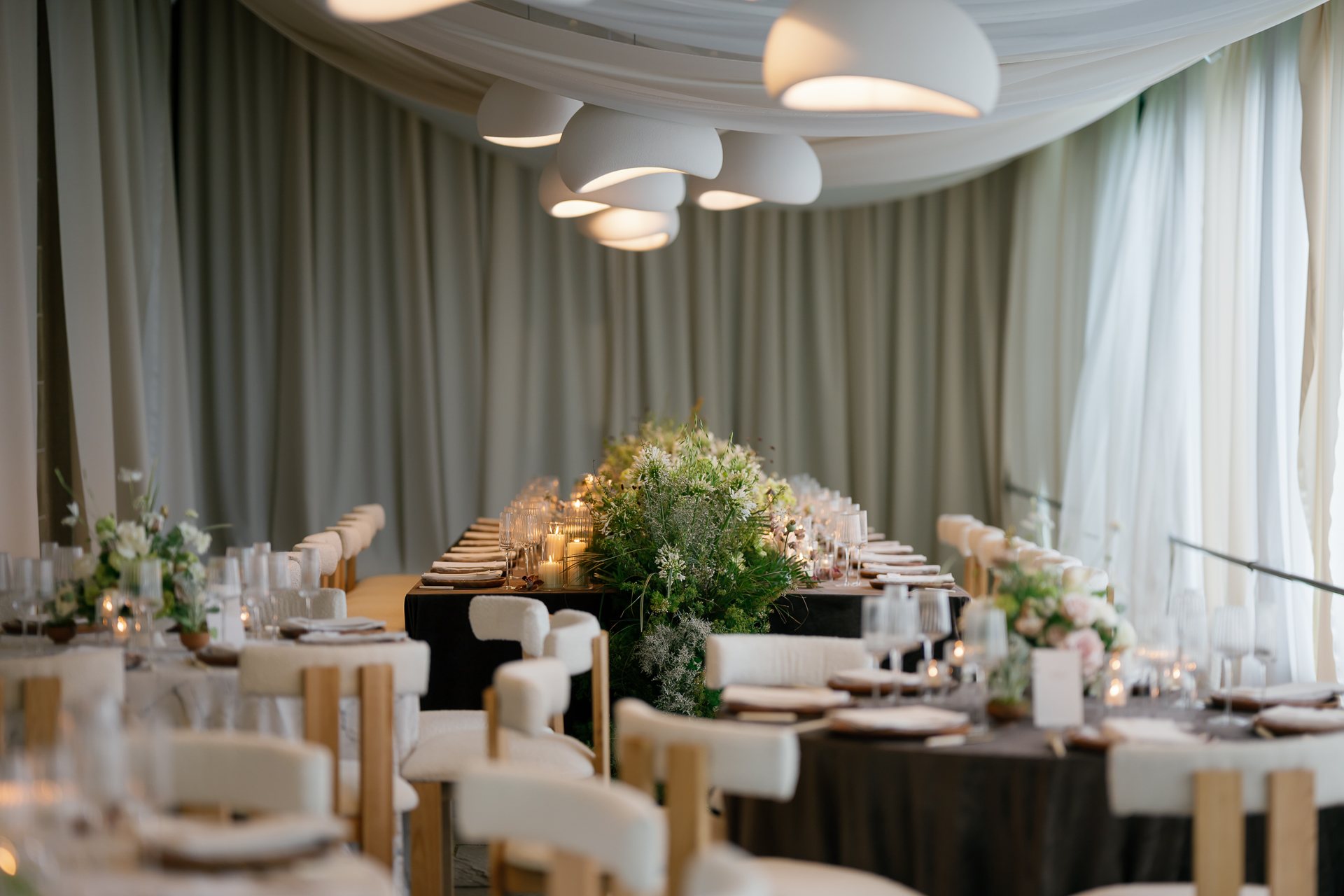 The dinner tent under draped fabric and white pendant lights. Photographed by Shukhrat Kamalov.