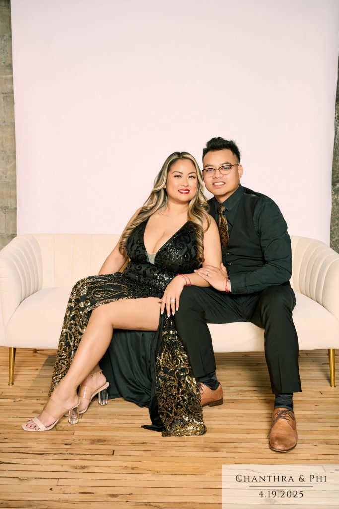Wedding guests on the Portrait Lounge sofa, she in a black and gold sequin gown