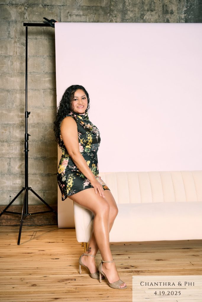 A wedding guest in a floral dress perched on the arm of the Portrait Lounge sofa