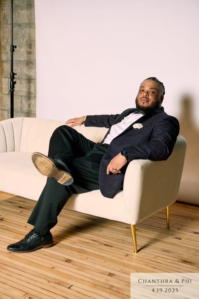 A wedding guest lounging on the Portrait Lounge sofa in a jacquard tuxedo jacket